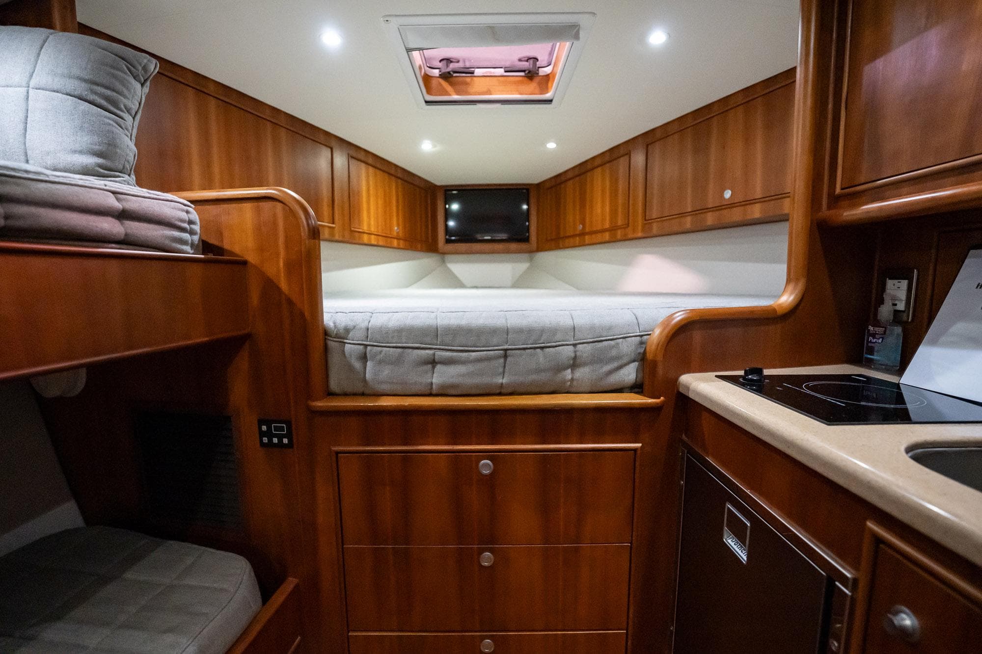 Luxurious cabin interior of 2012 Winter Custom Yachts 38 Express with wood finish and cozy bedding.
