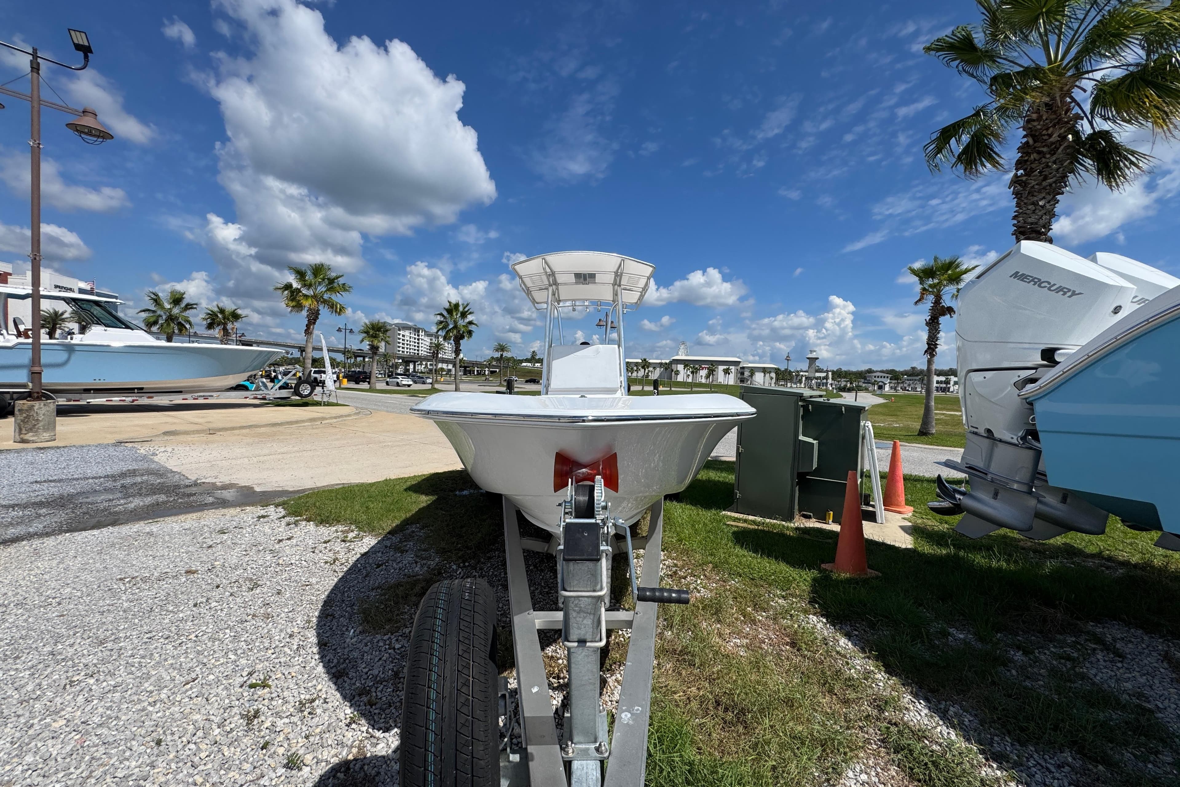 2026 Contender 26 Bay boat on trailer, sunny day, palm trees, blue sky.