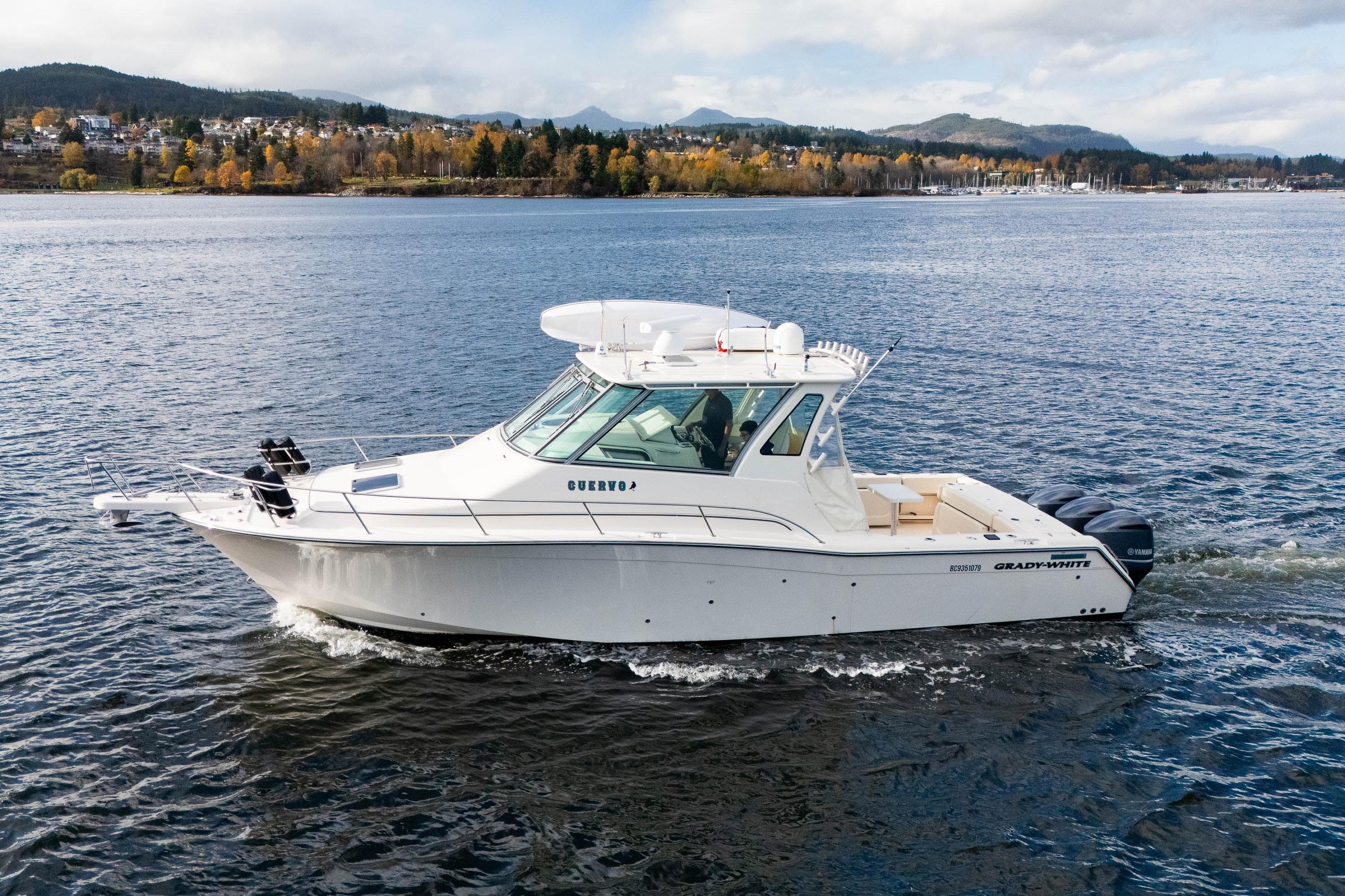 2015 Grady-White Express 370 cruising on a scenic lake with autumn foliage.