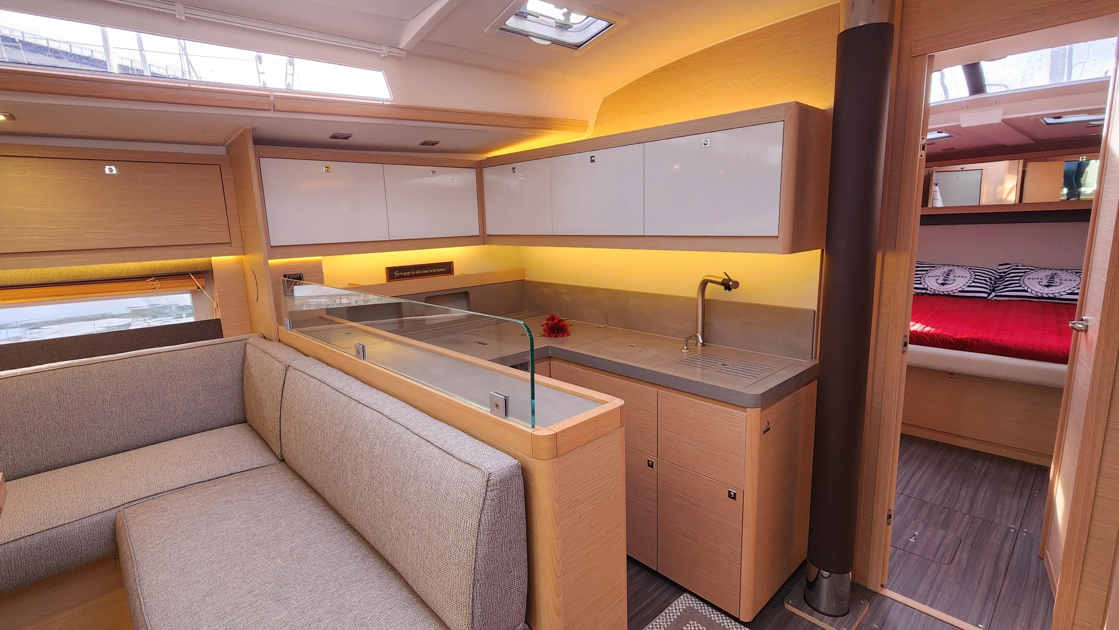 Modern interior of 2023 Dufour 530 yacht with sleek kitchen and cozy seating area.