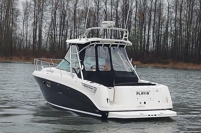 2009 Sea Ray 290 Amberjack boat on calm water, surrounded by trees.