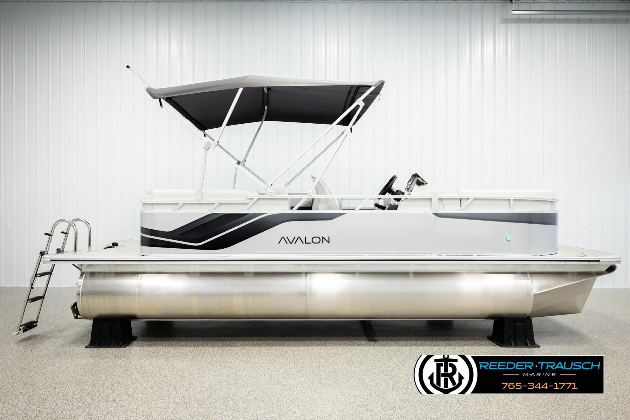 2026 Avalon VLS QL pontoon boat with canopy in showroom, side view.
