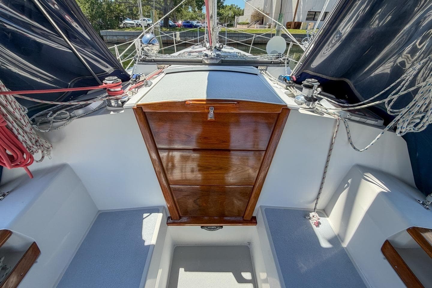 Cockpit of a 1993 Catalina 42 sailboat with wooden hatch and rigging.