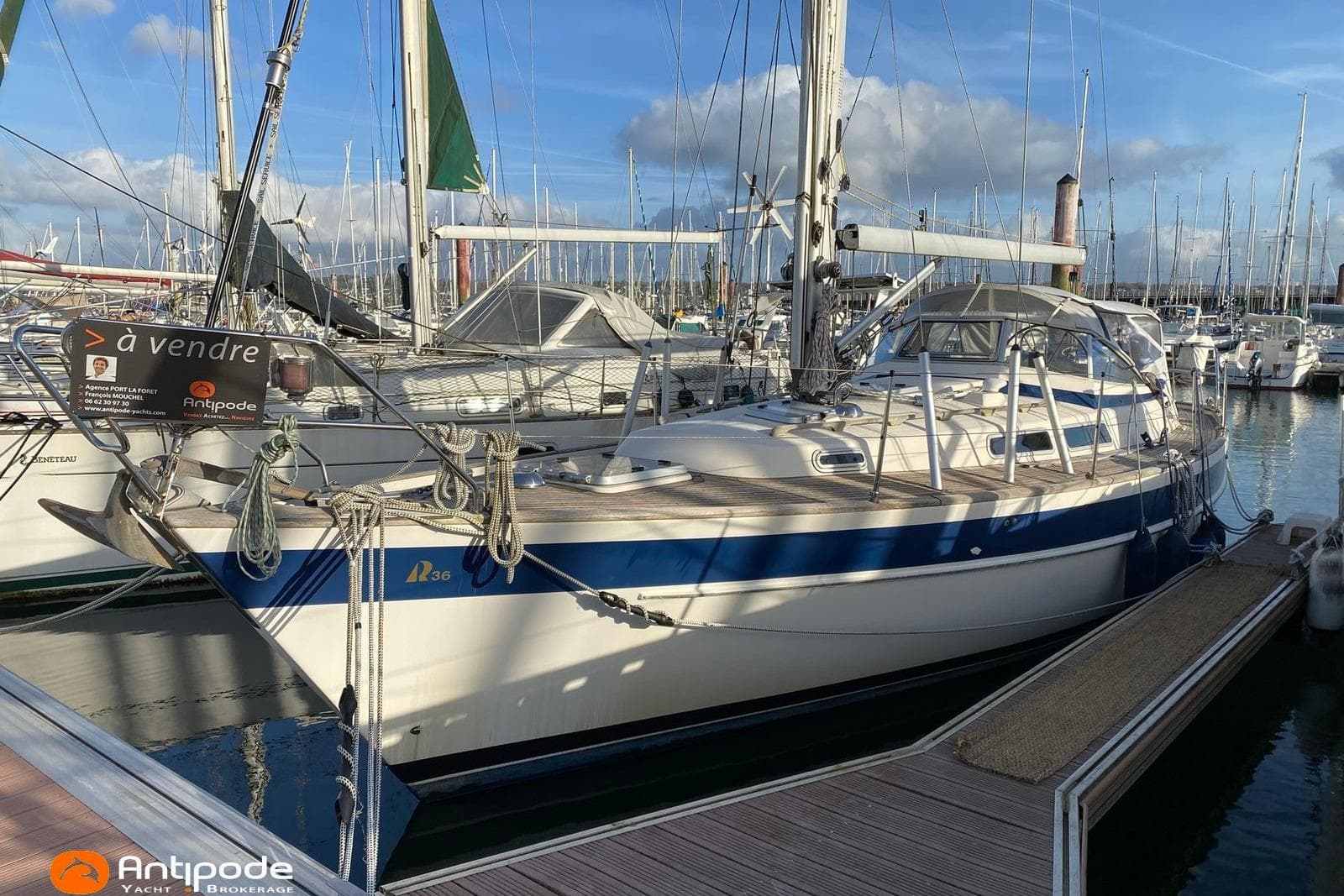 1992 Hallberg-Rassy 36 sailboat docked, for sale, with clear skies and marina background.