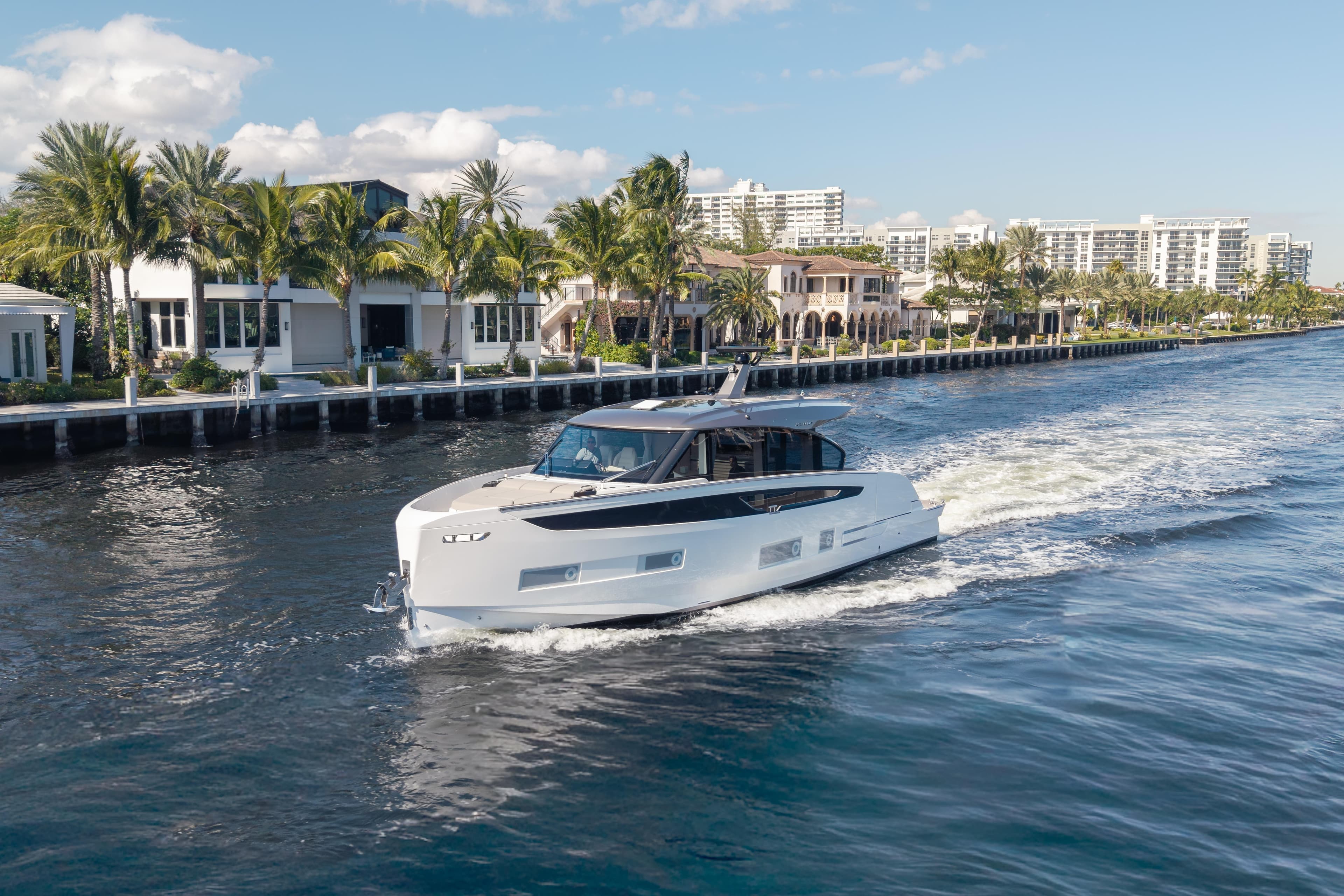 2025 Azimut Seadeck 6 yacht cruising near luxury waterfront homes.
