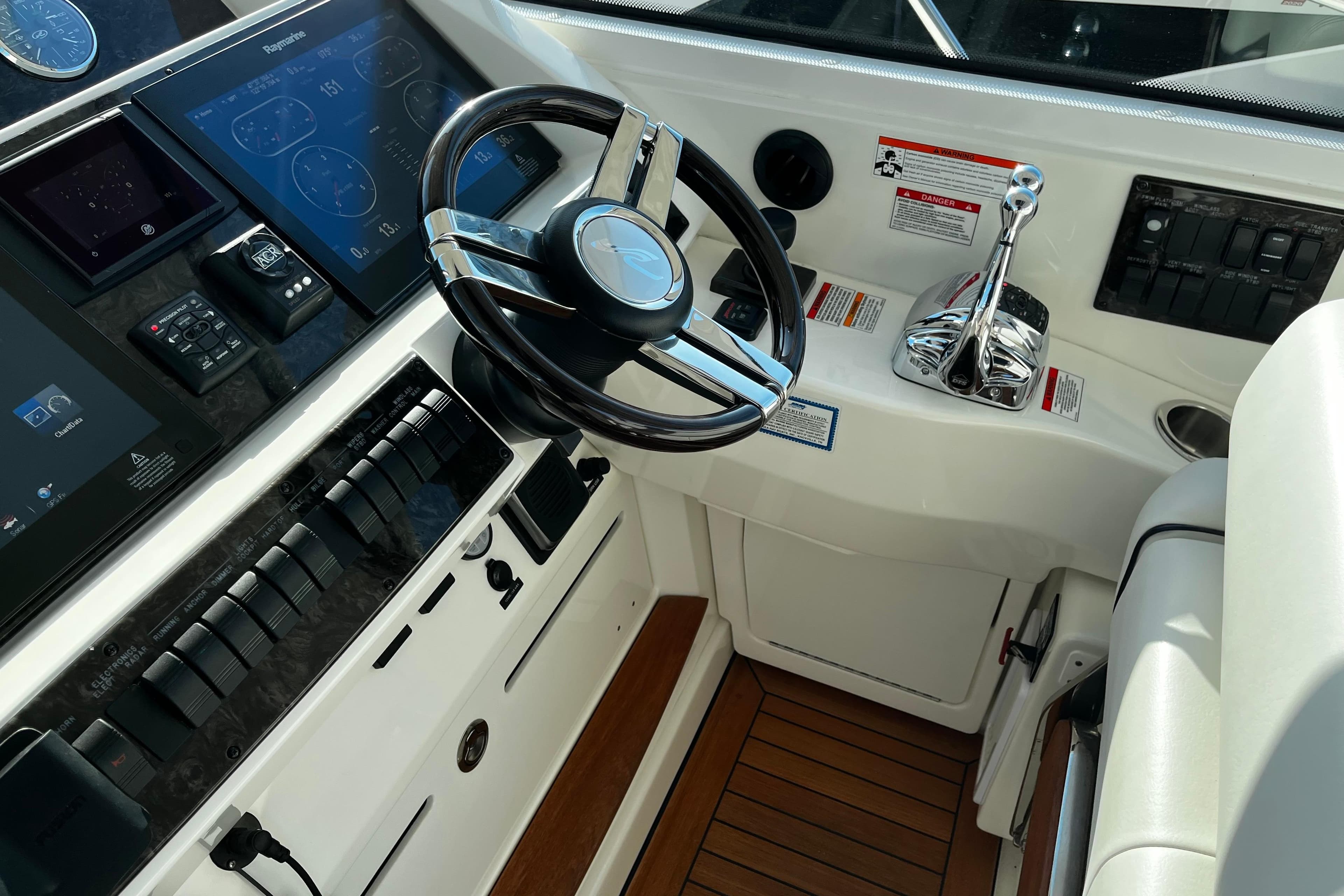 Cockpit of 2010 Sea Ray 450 Sundancer with modern controls and steering wheel.