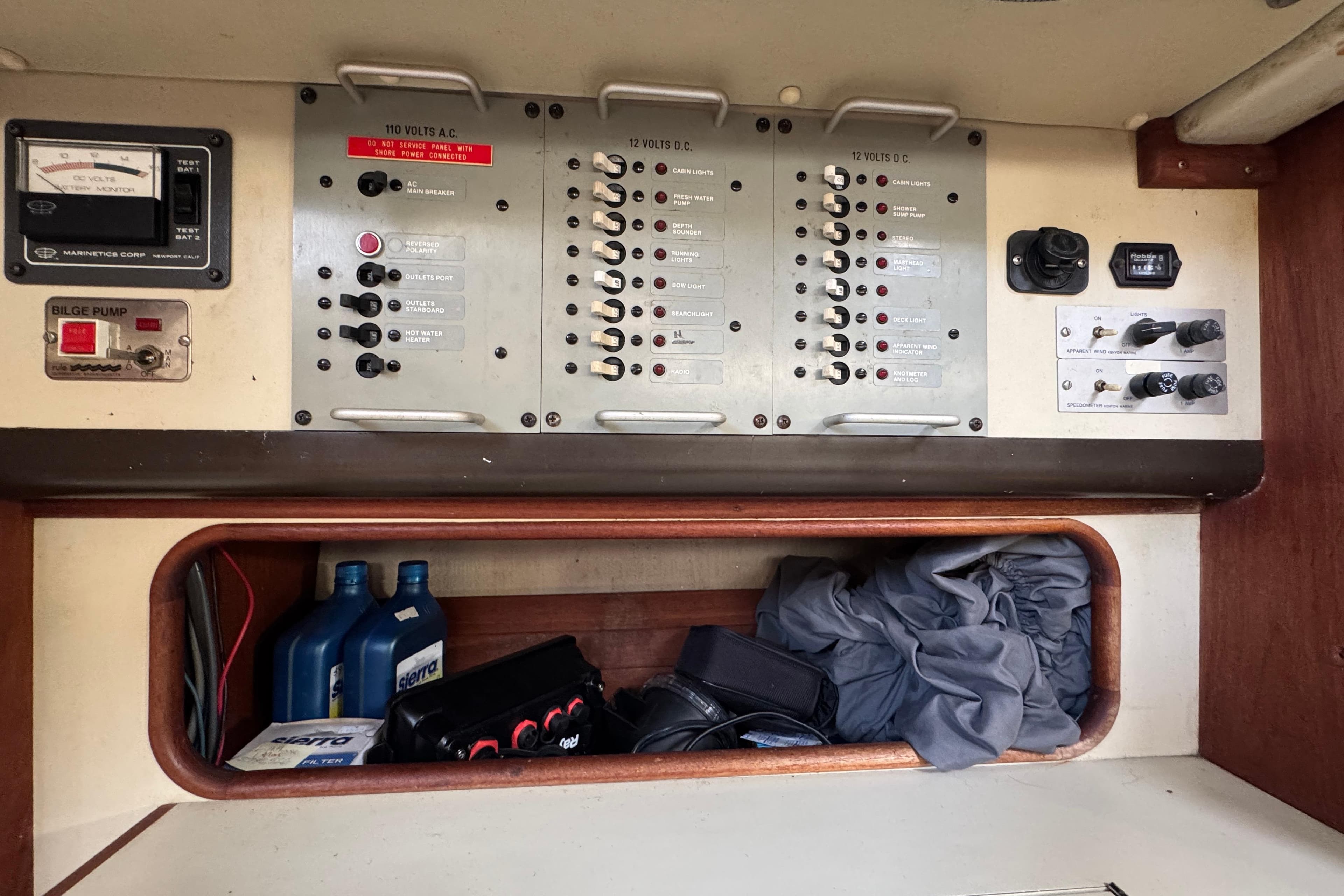 Electrical control panel on a 1982 C&C 37 sailboat, with storage compartment below.