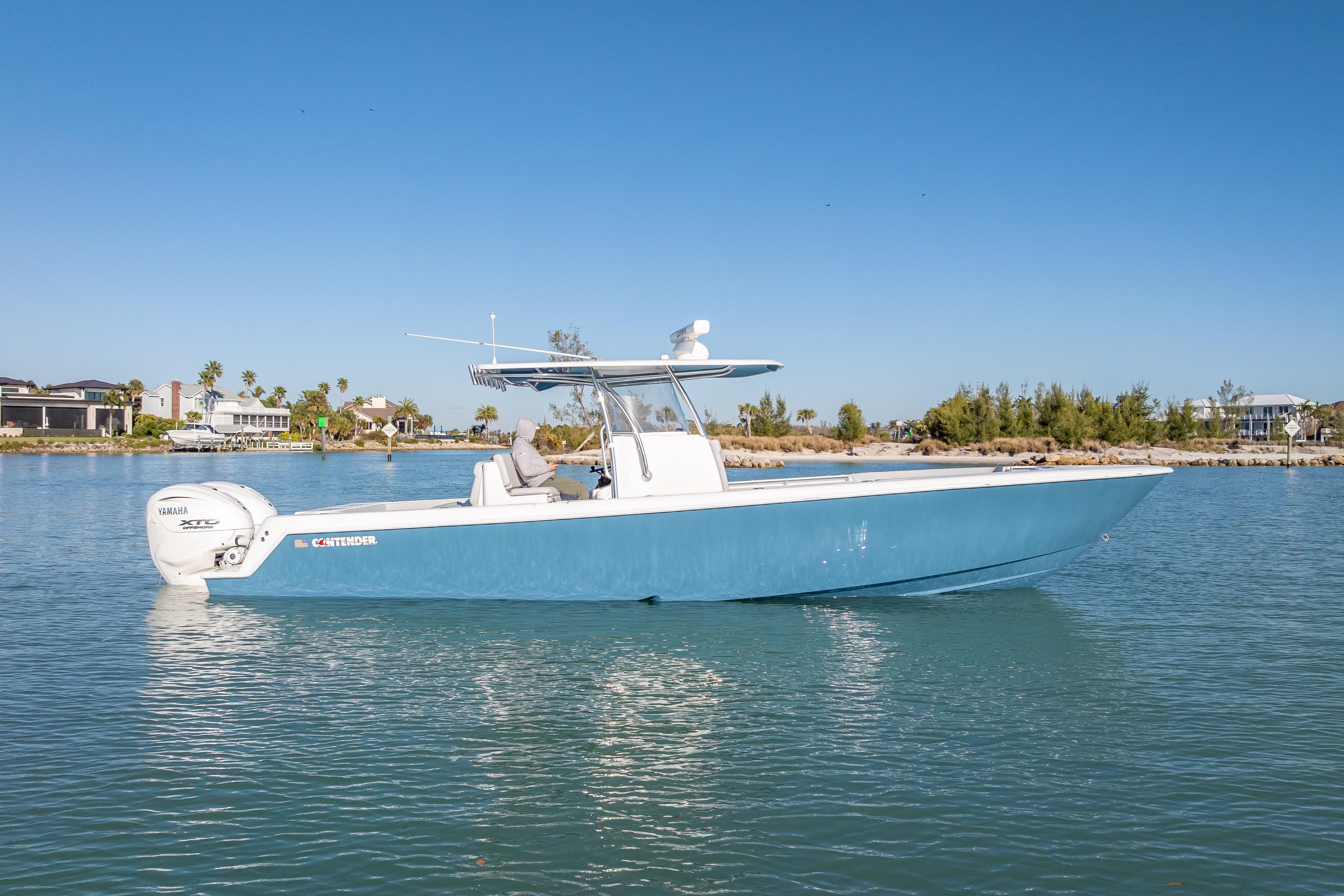 2026 Contender 35 ST boat on calm water, featuring sleek blue design and Yamaha engines.