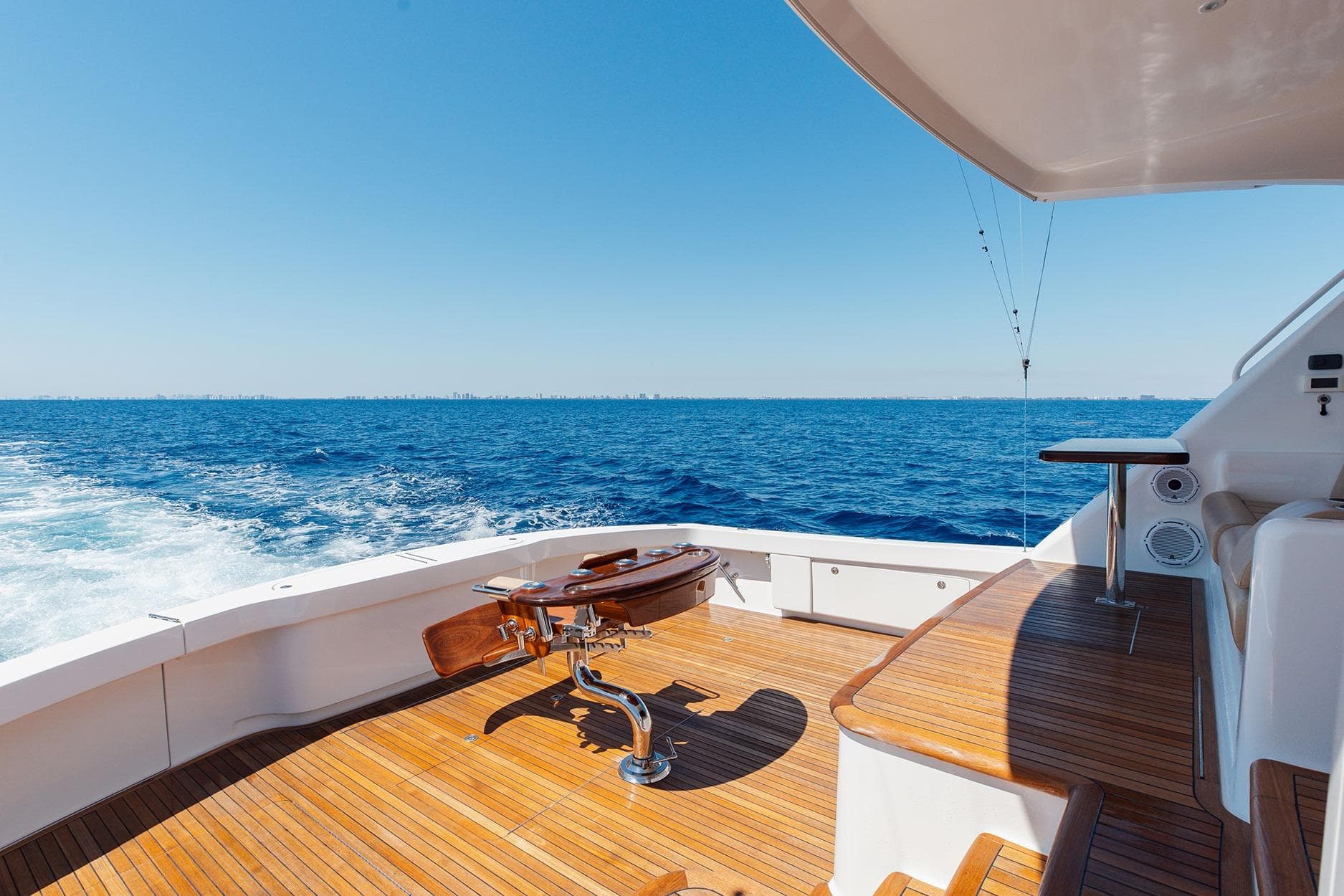 Luxurious 2016 Viking 82 Sky Bridge yacht deck with ocean view and wooden flooring.