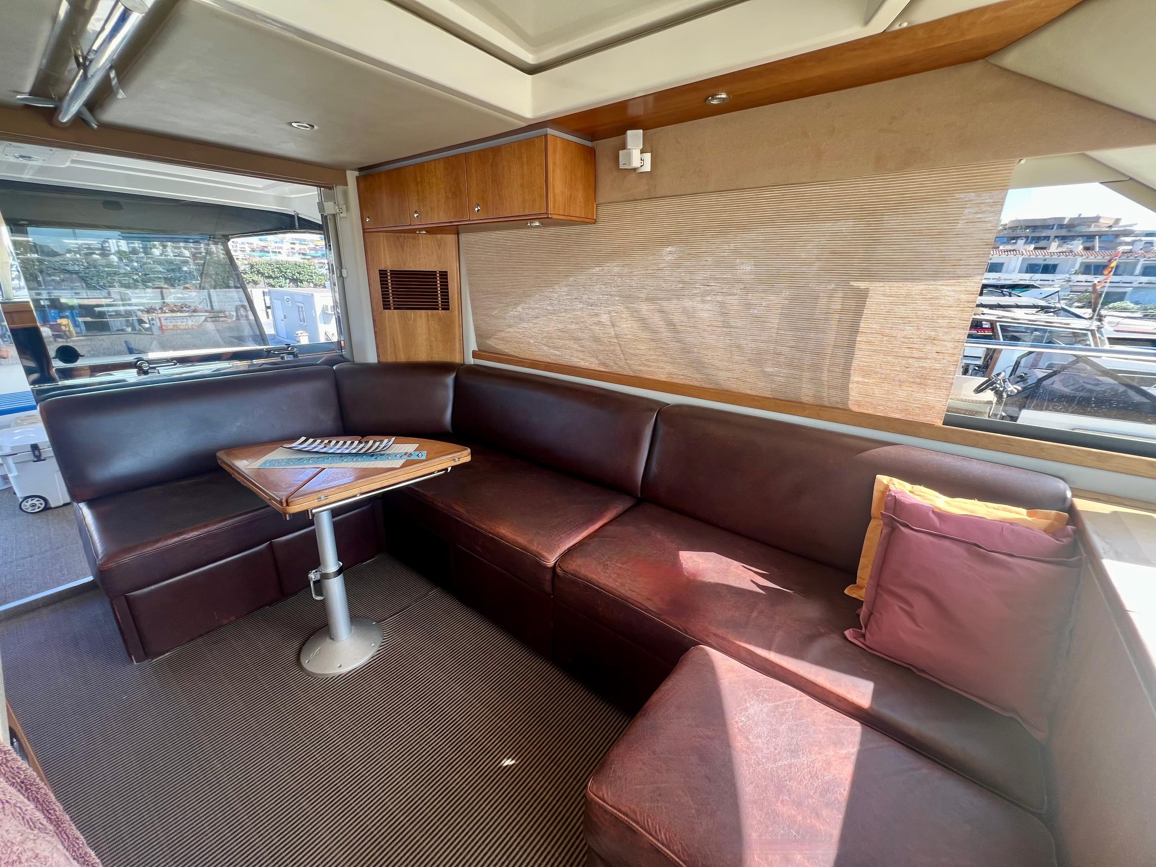 Interior of 2008 Riviera 4700 Sport Yacht with leather seating and wooden table.
