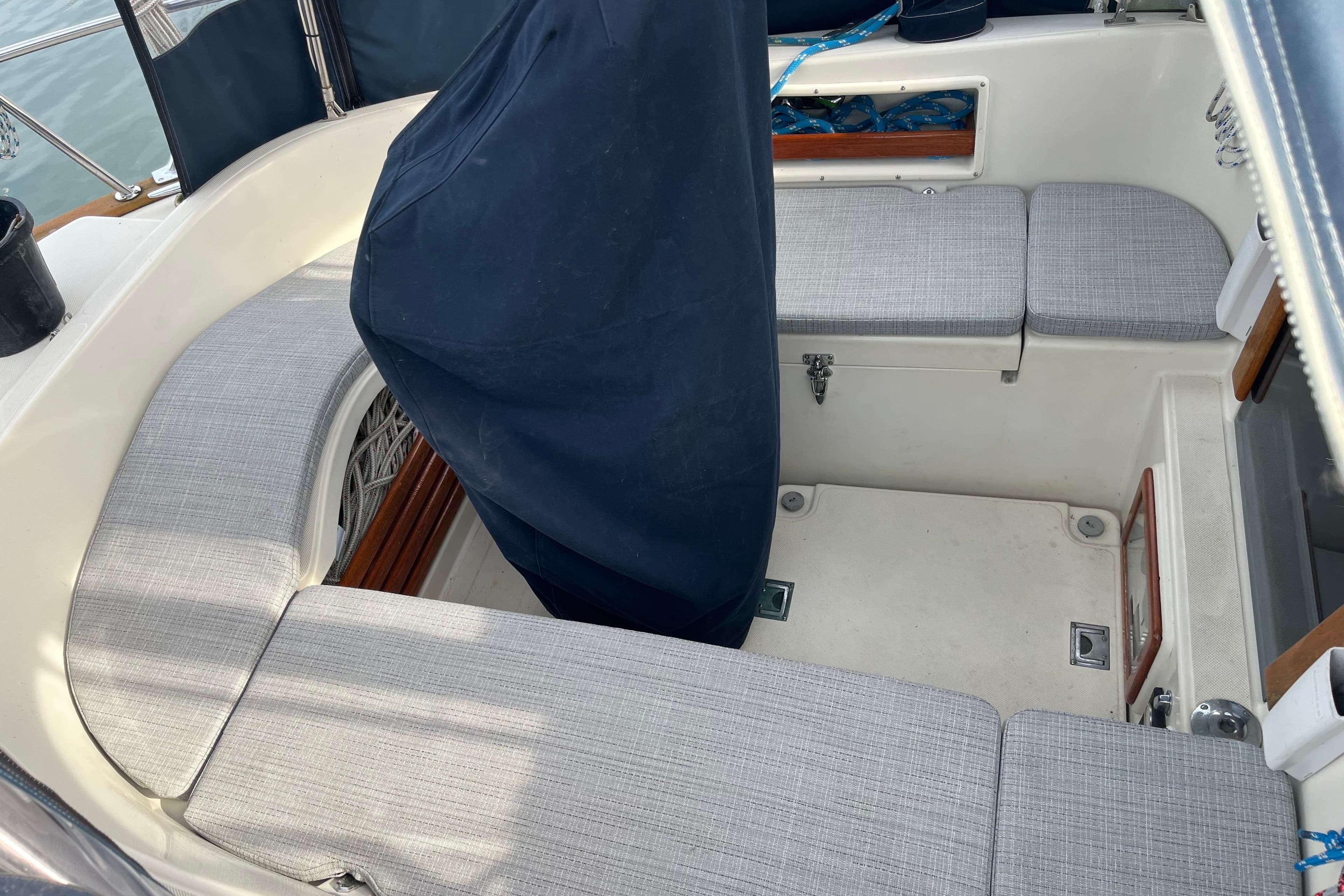 1997 Pacific Seacraft Crealock 34 cockpit with cushioned seating and covered helm.