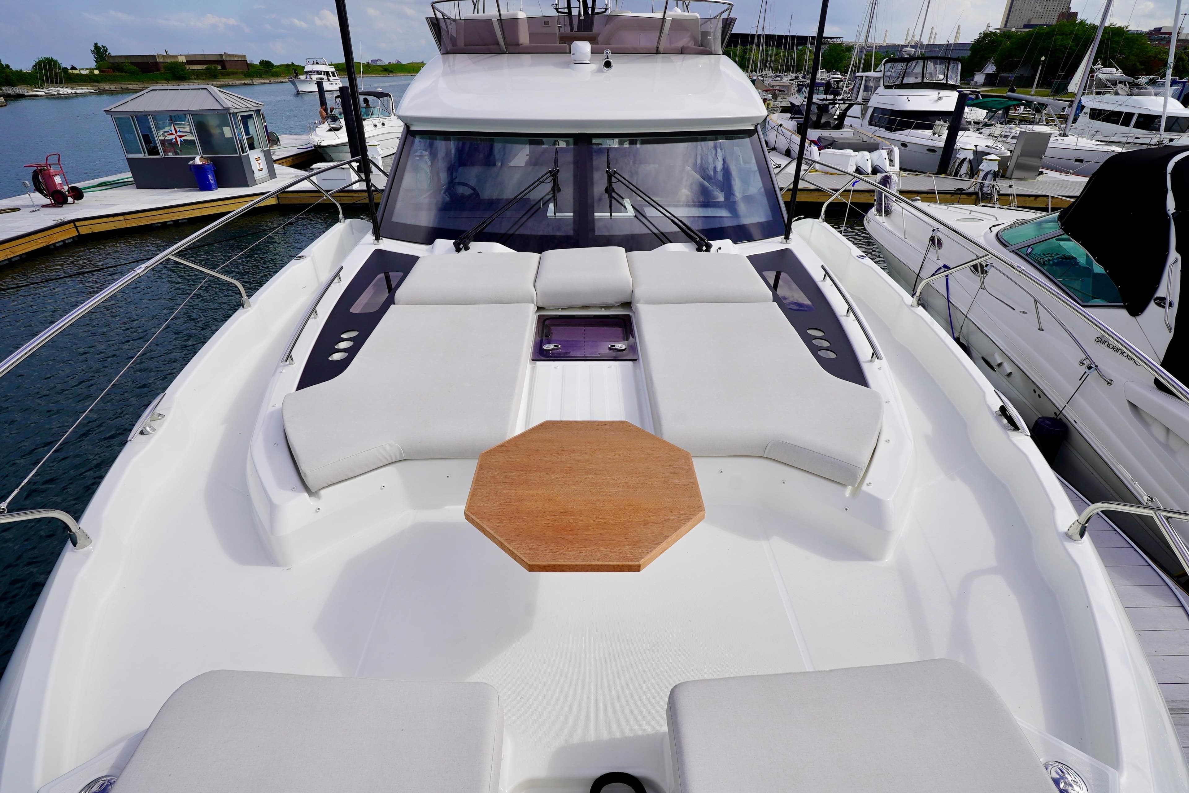 Prestige F5.7 yacht 2025 model, featuring spacious deck and seating area at marina.