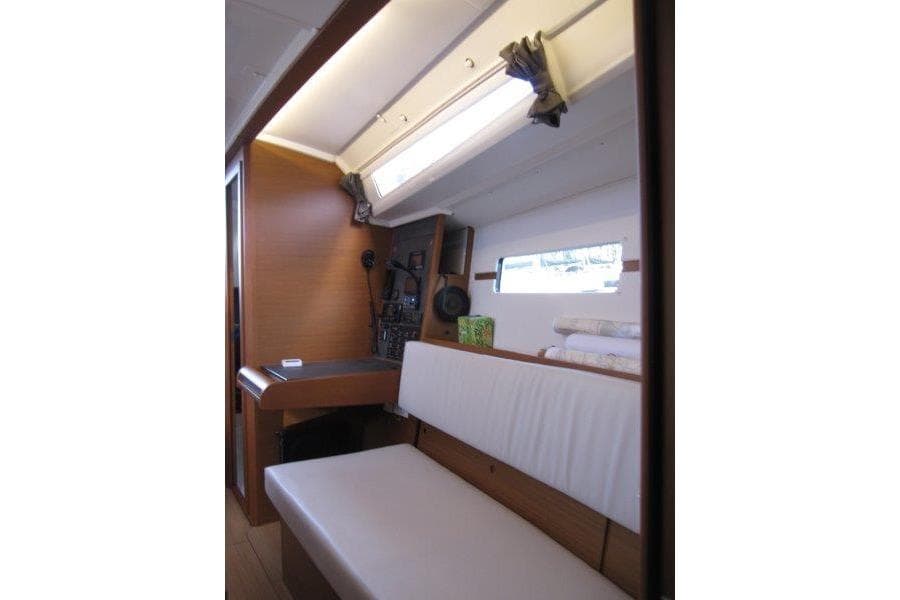 Interior of 2022 Jeanneau Sun Odyssey 349 sailboat, featuring seating and navigation area.