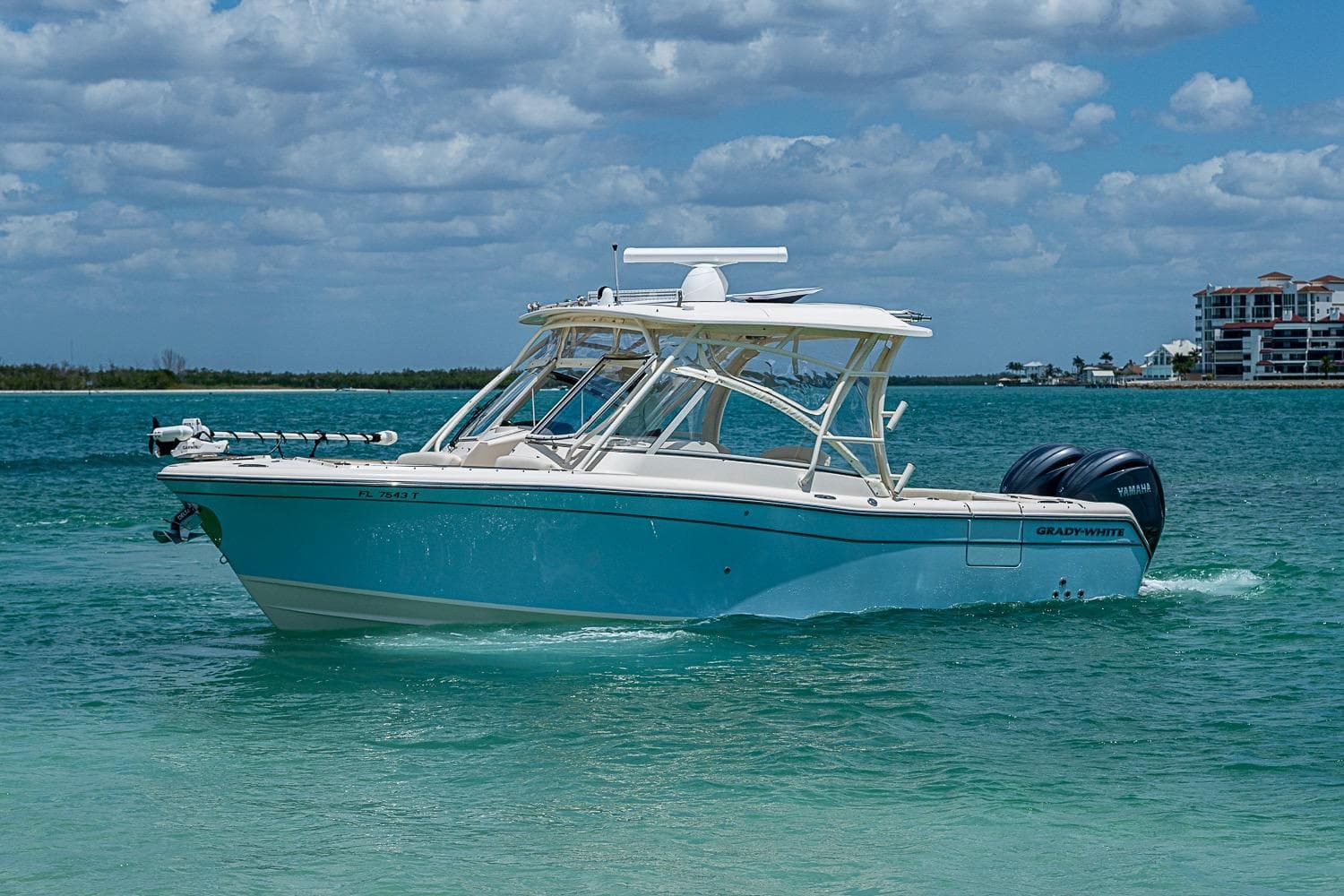 2022 Grady-White Freedom 285 boat cruising on turquoise water under a cloudy sky.