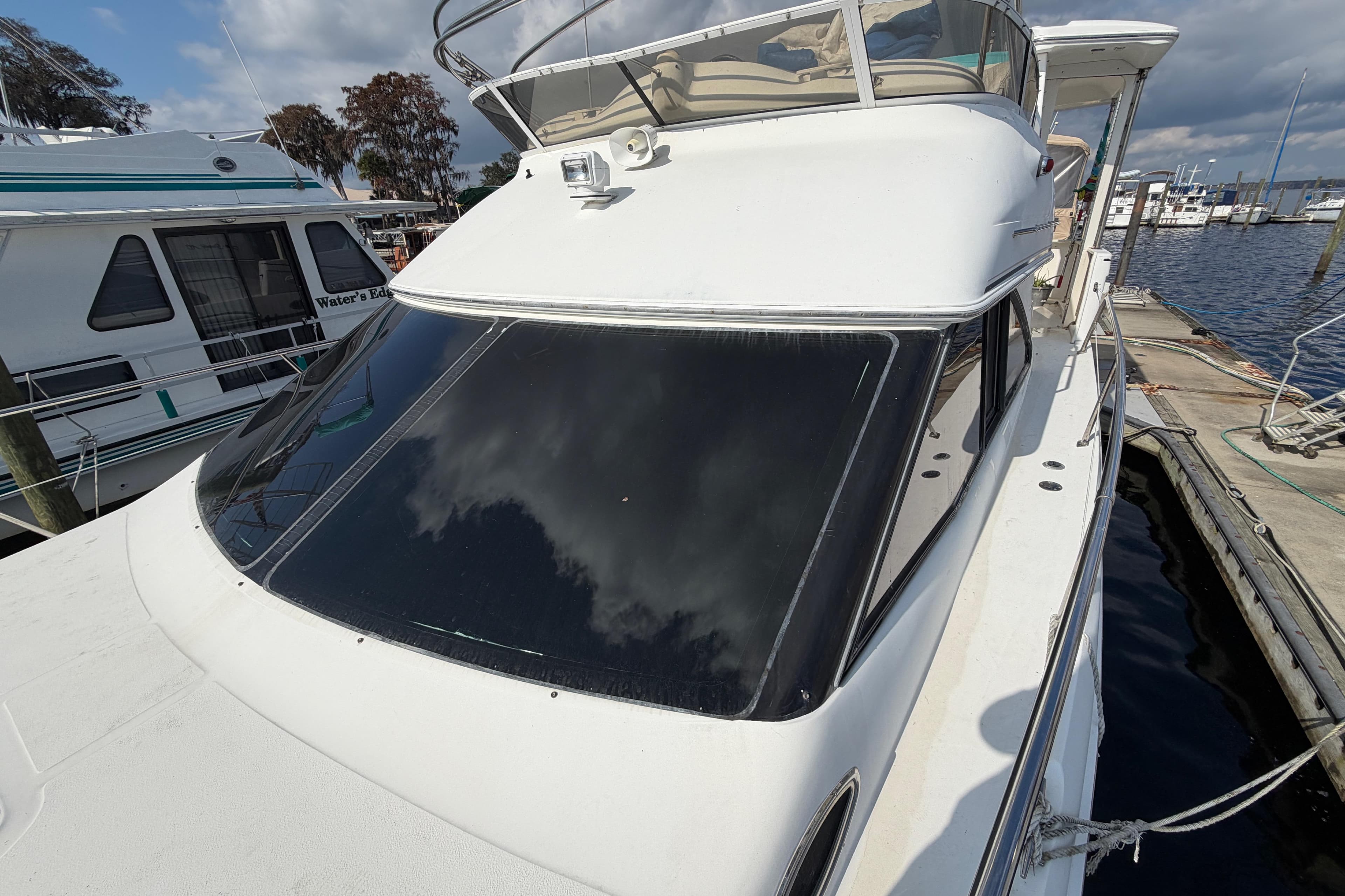 1997 Sea Ray 370 Aft Cabin yacht docked at marina under cloudy sky.
