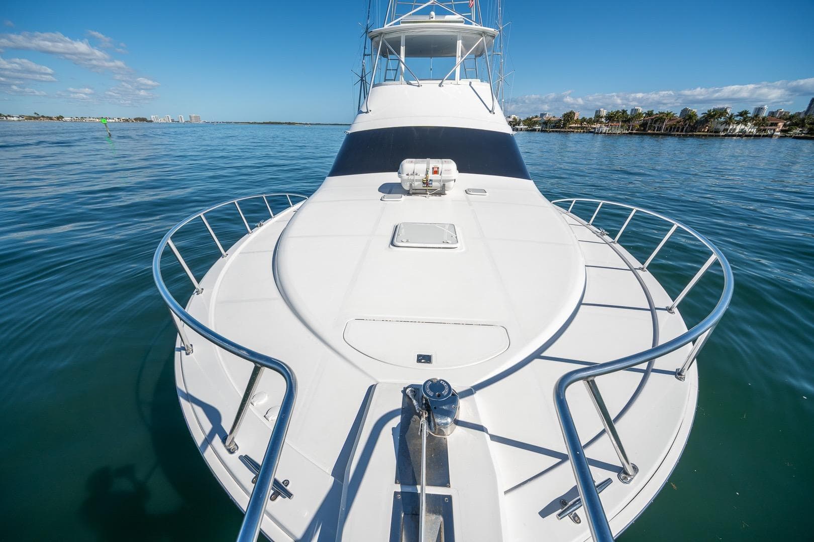 2009 Cabo 52 Flybridge yacht on calm water, showcasing sleek design and spacious deck.