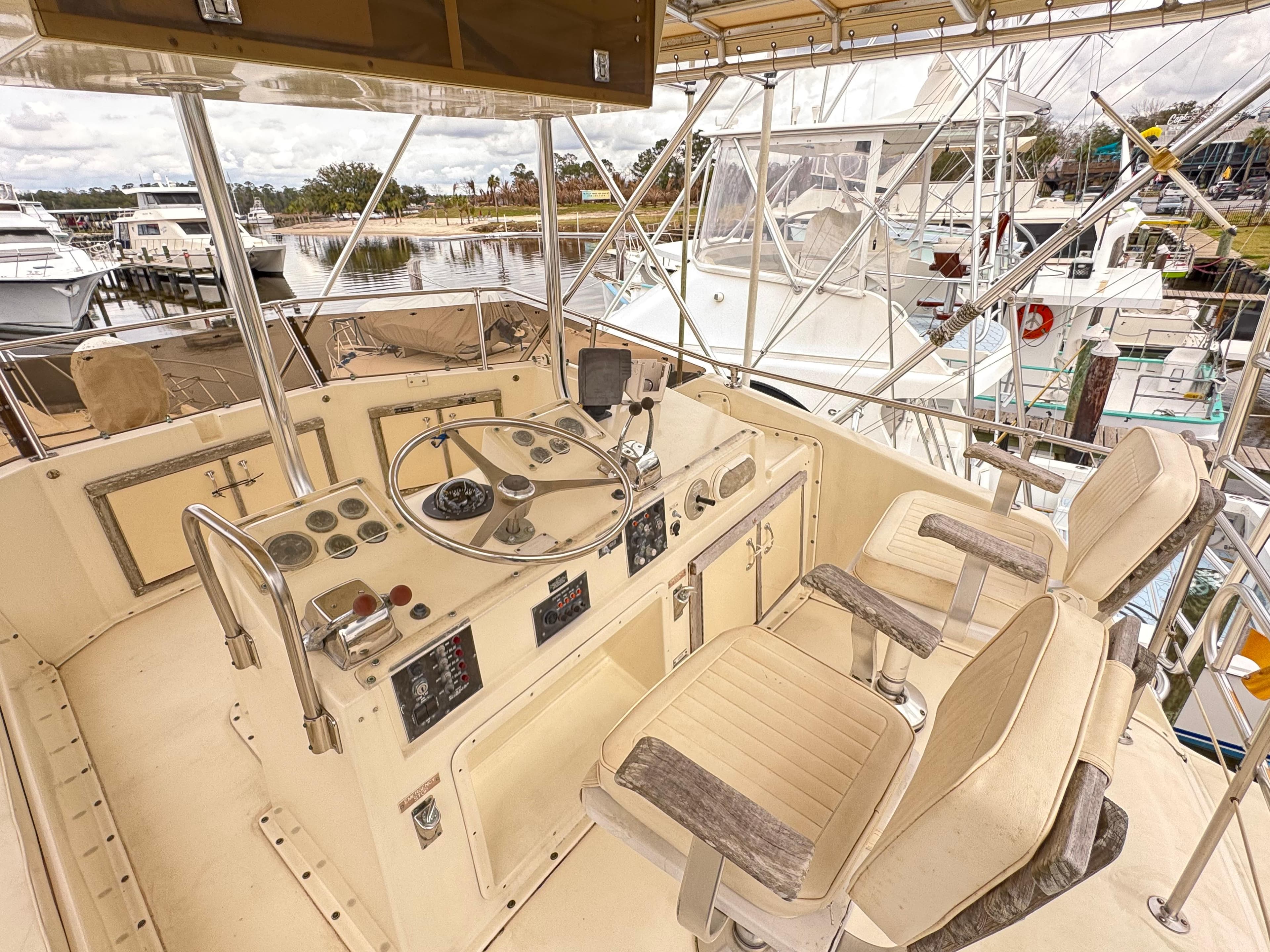 1984 Hatteras 46 Convertible yacht helm with dual seats and control panel.