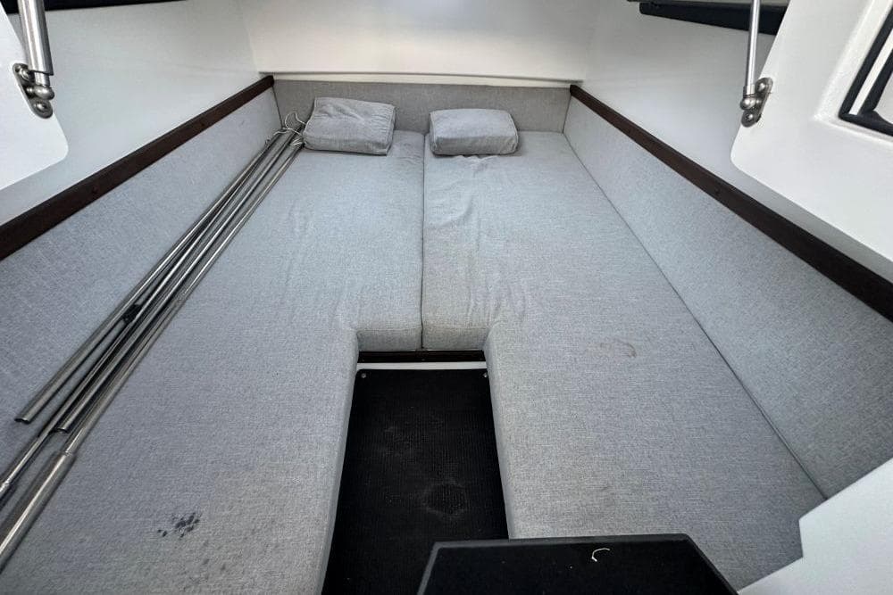2019 Axopar 37 T-Top cabin interior with gray cushions and metal poles.