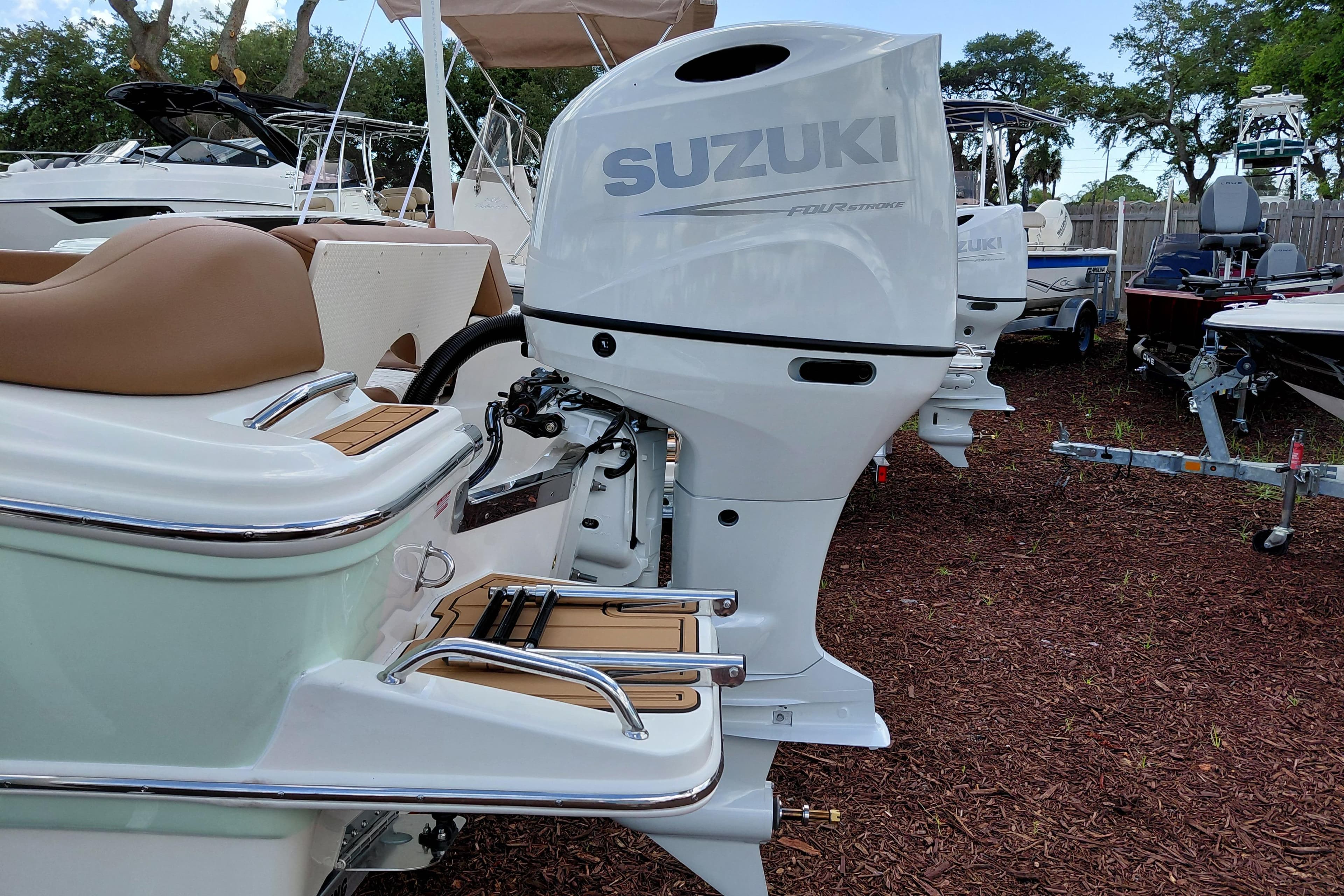 2026 Pioneer 202 Islander boat with Suzuki outboard motor in a marina setting.