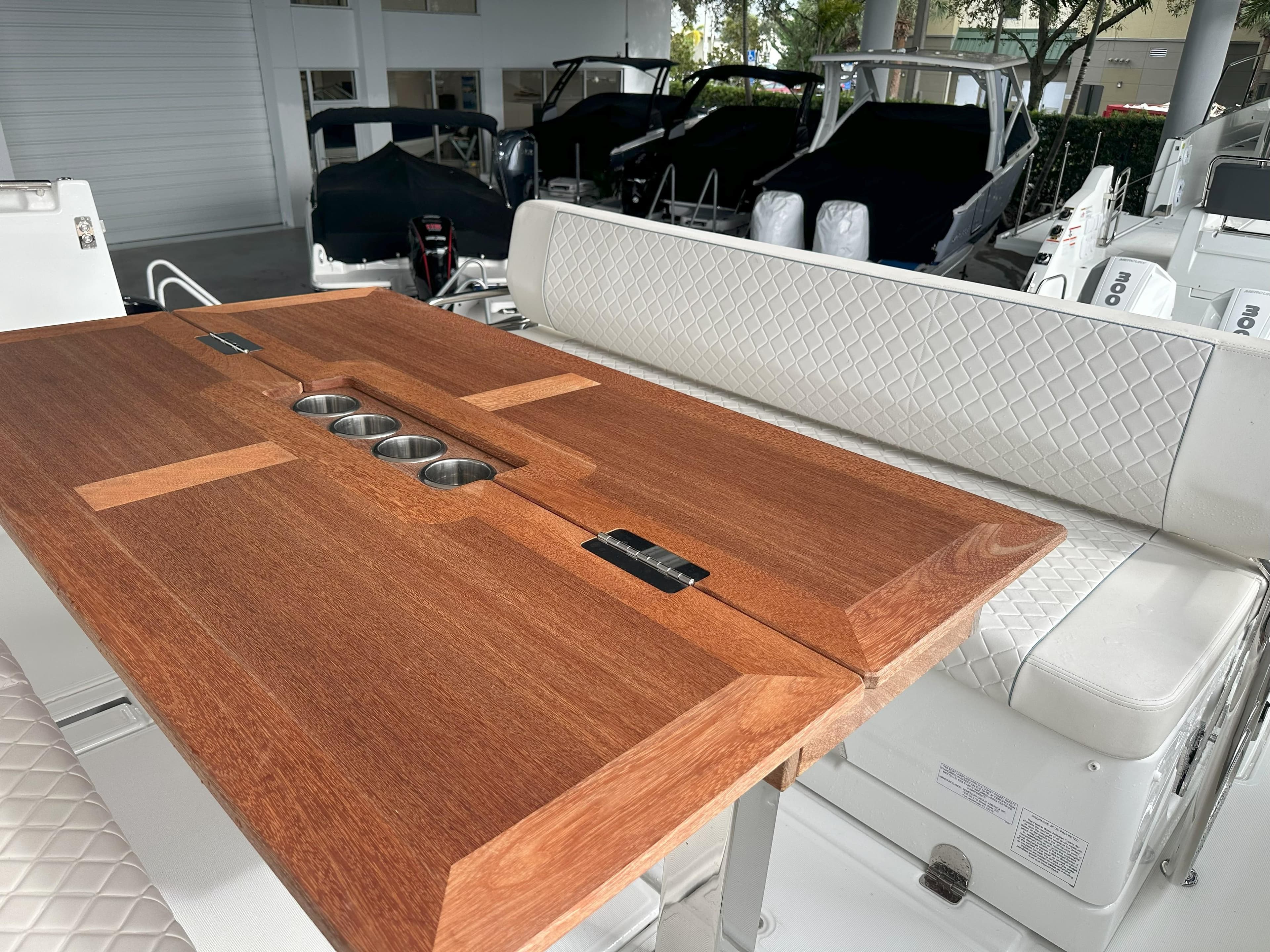 2024 Jeanneau DB 43 boat interior with wooden table and cushioned seating.