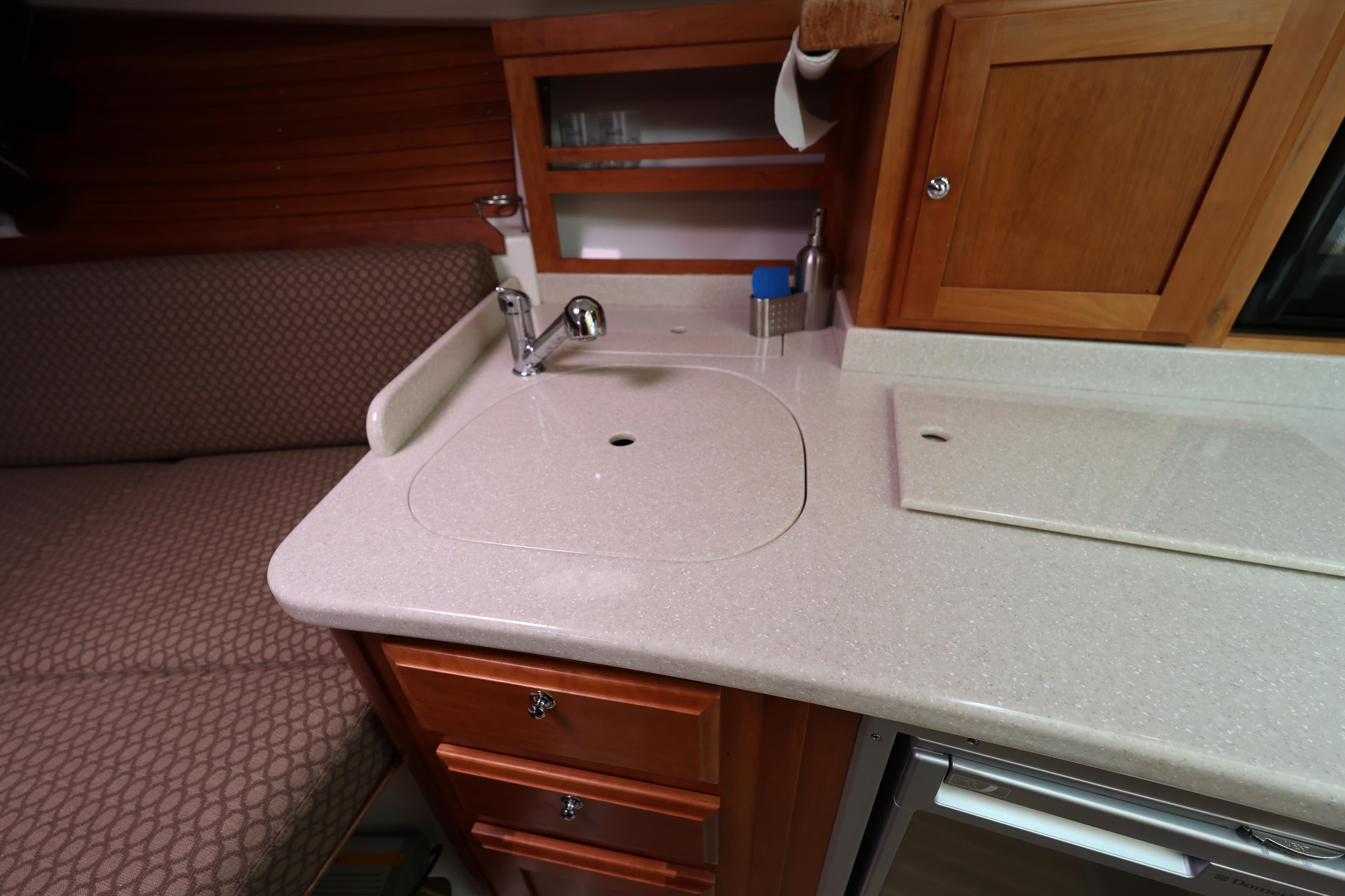 Interior of 2011 Back Cove 30 boat featuring a compact kitchen area with sink and cabinets.