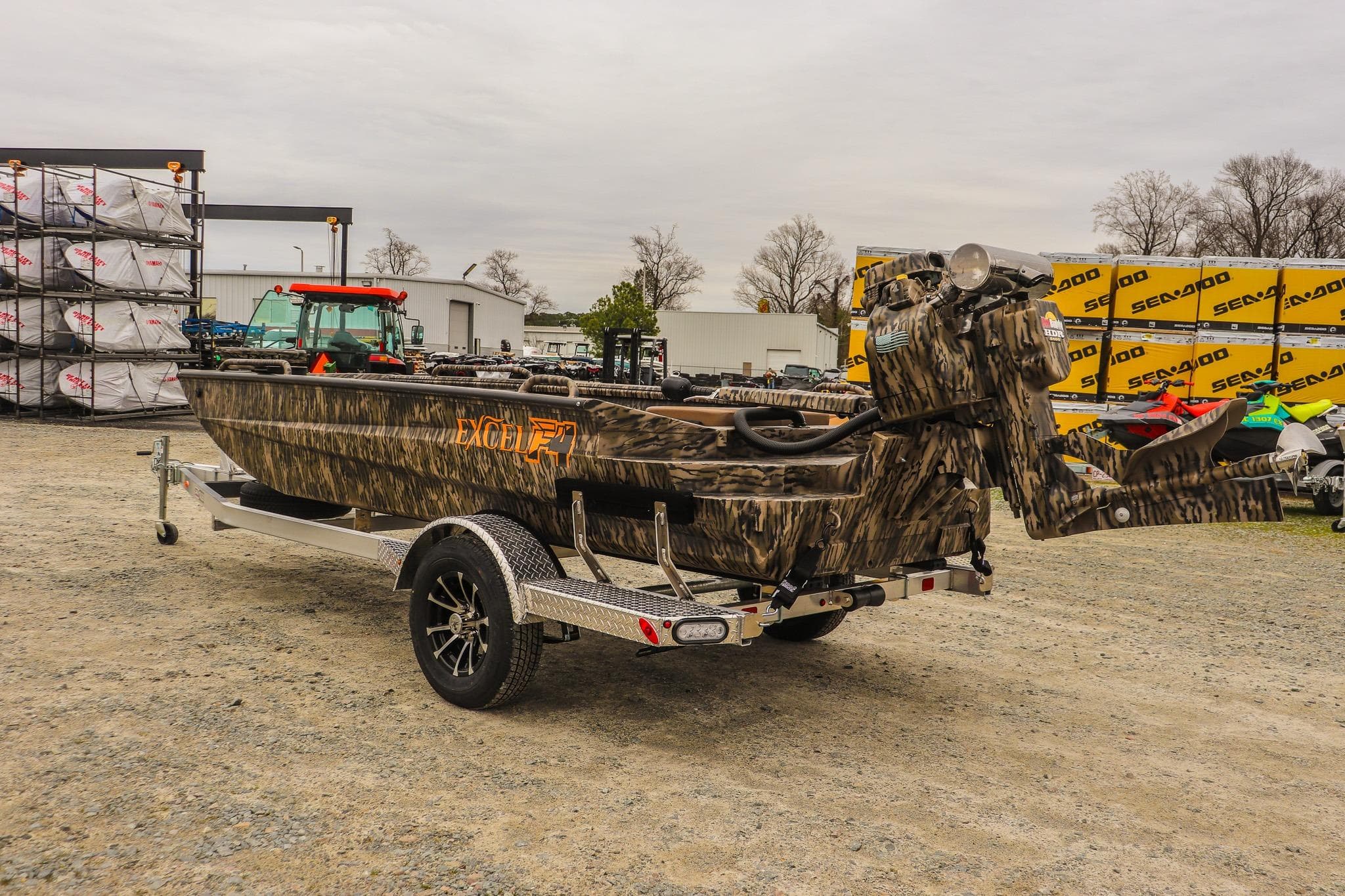 Camouflage-patterned 2026 Excel 1751 F4 Pro boat on a trailer in an outdoor lot.