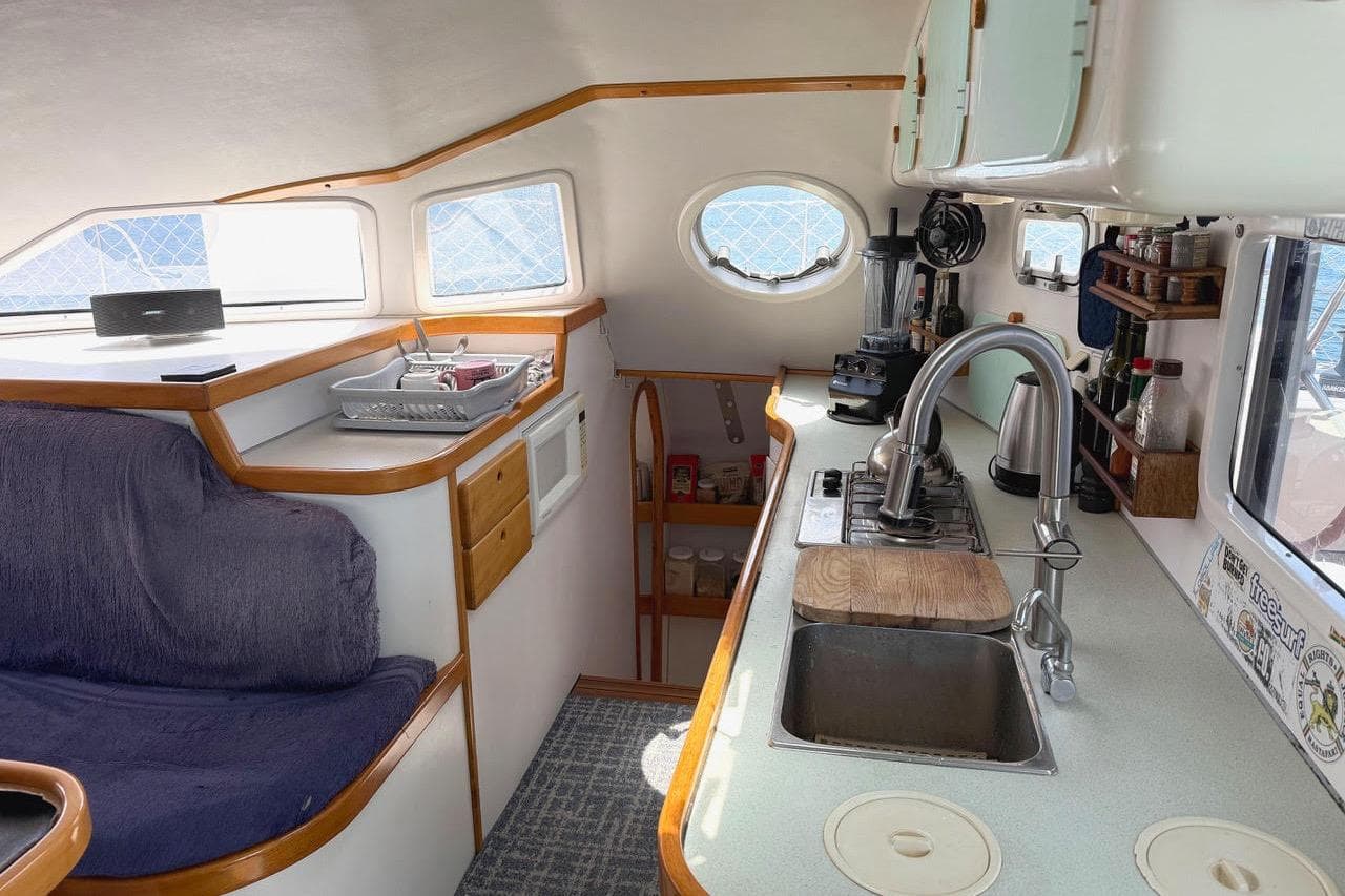 Interior of a 2004 Outremer Standard yacht featuring a cozy kitchen and seating area.