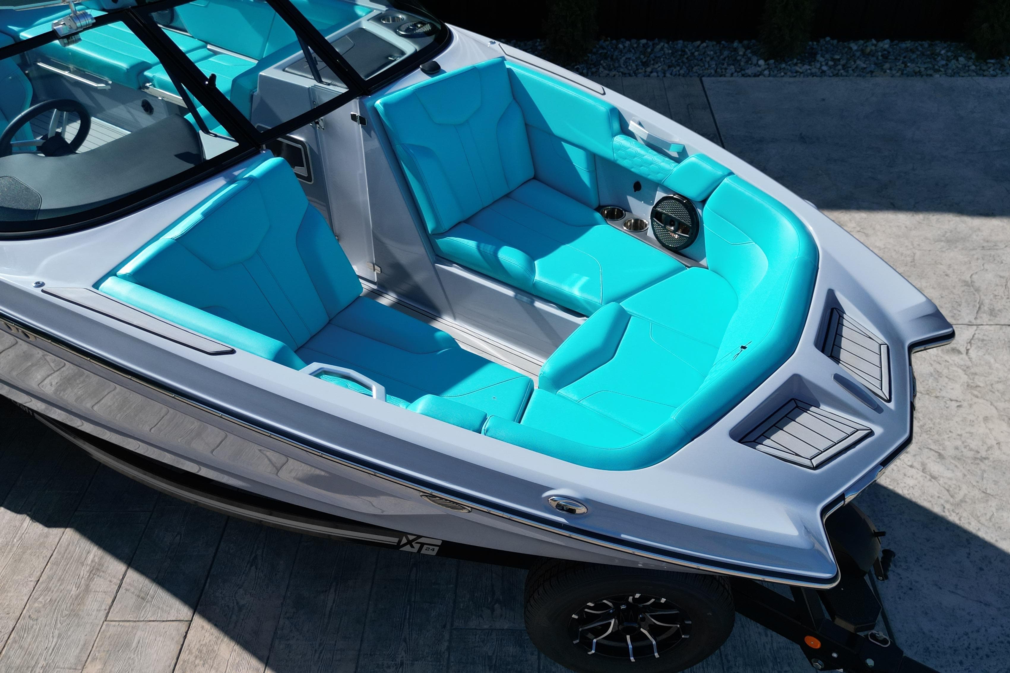 2025 MasterCraft XT24 boat with vibrant turquoise seating and sleek design.