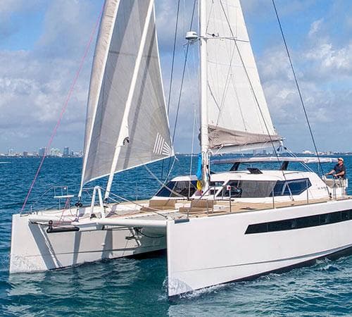 2025 Seawind 1600 Passagemaker catamaran sailing on blue ocean under clear skies.
