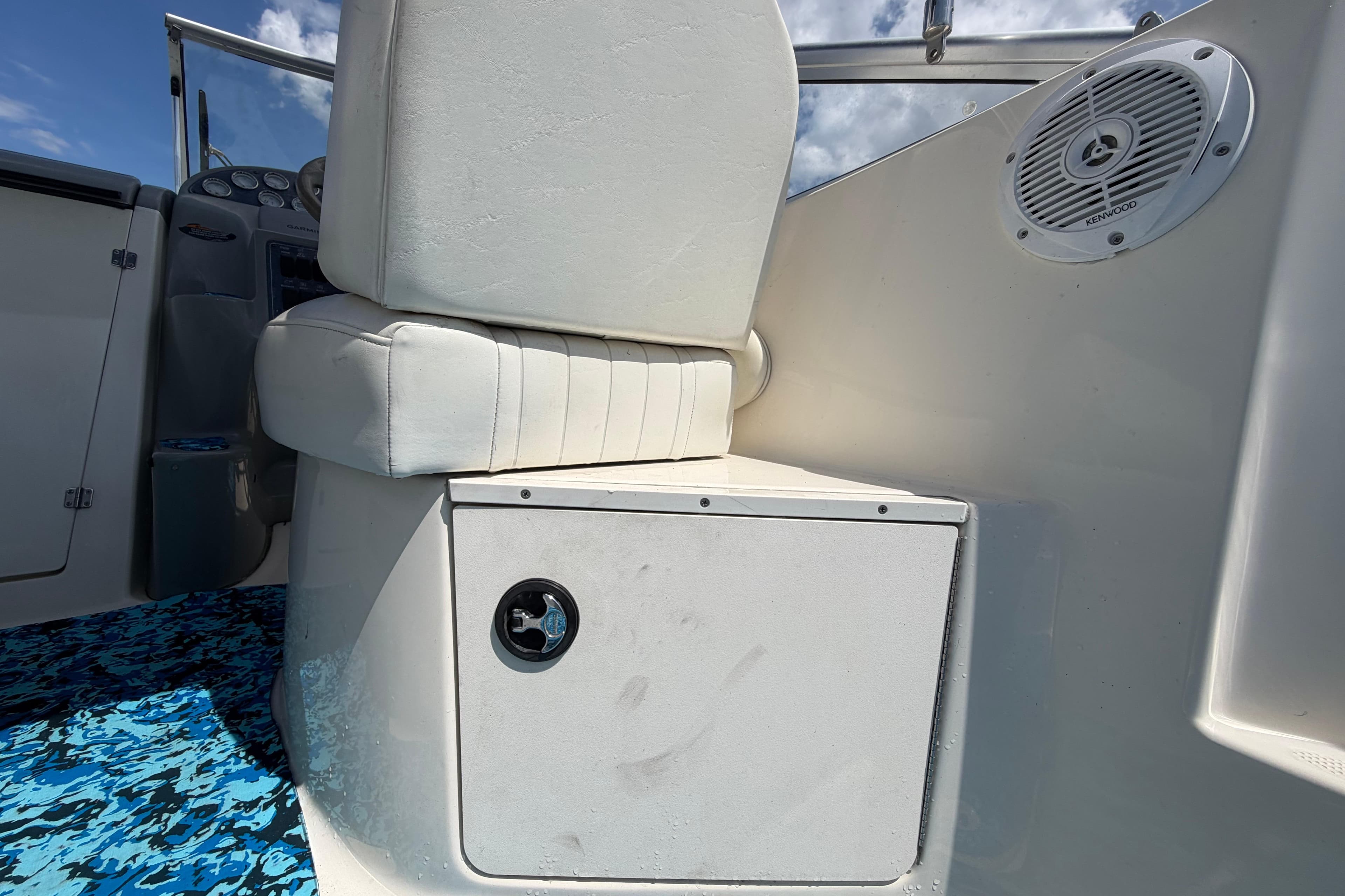 2004 Bayliner 2452 Ciera Express interior with white seating and Kenwood speaker.