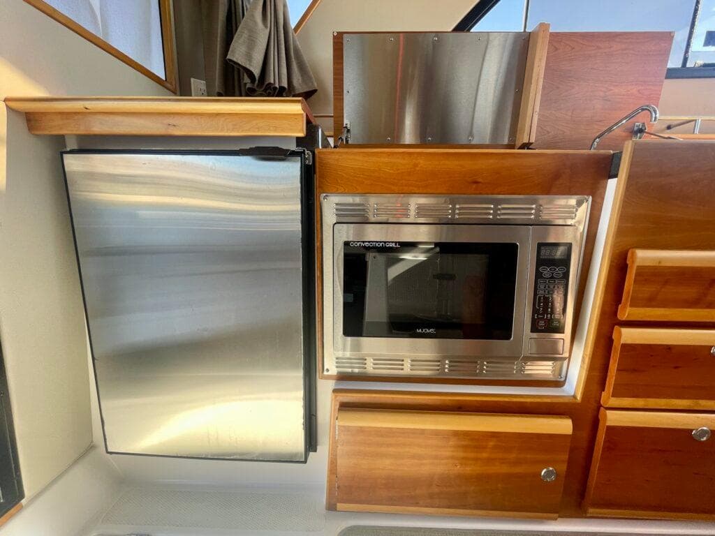 2017 Cutwater C-302 Sport Coupe kitchen with stainless steel fridge and microwave.