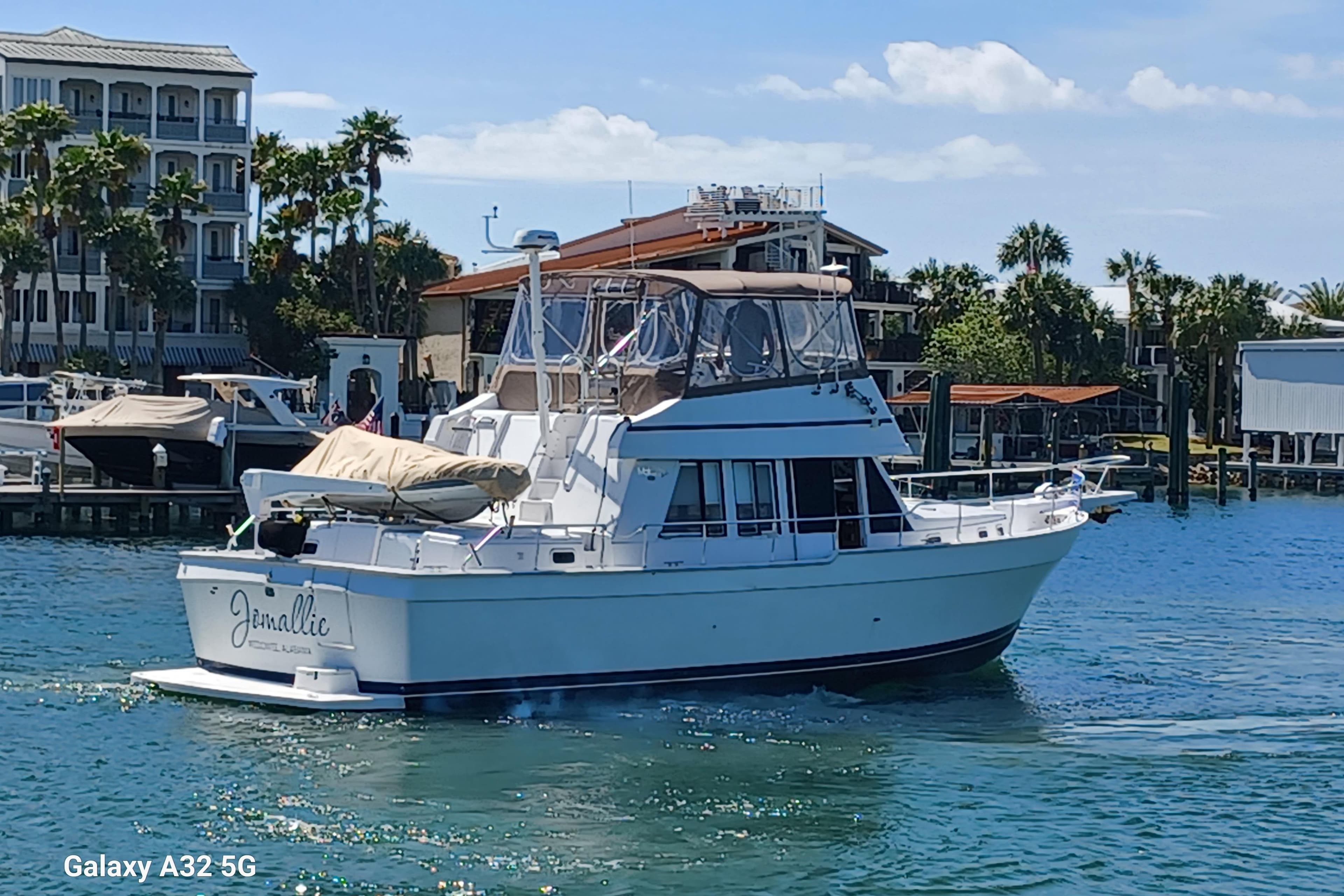 1999 Mainship 43 Trawler Aft Cabin cruising in a scenic marina setting.