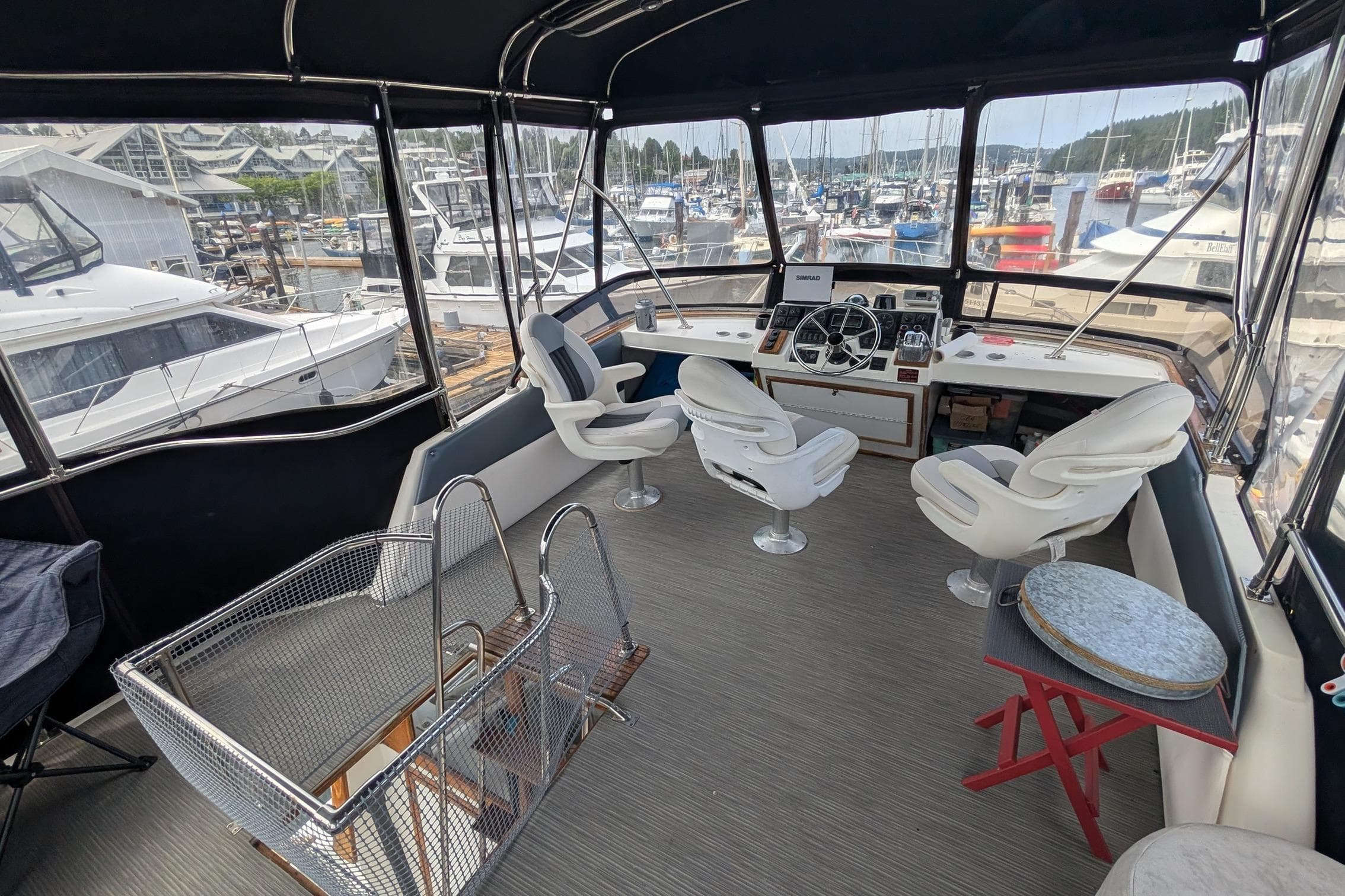 1990 Bayliner 3888 Motoryacht cockpit with helm, seating, and marina view.