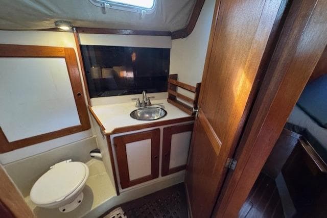 1979 CAL 39 MK II Tall Rig yacht bathroom with sink, toilet, and wooden cabinetry.