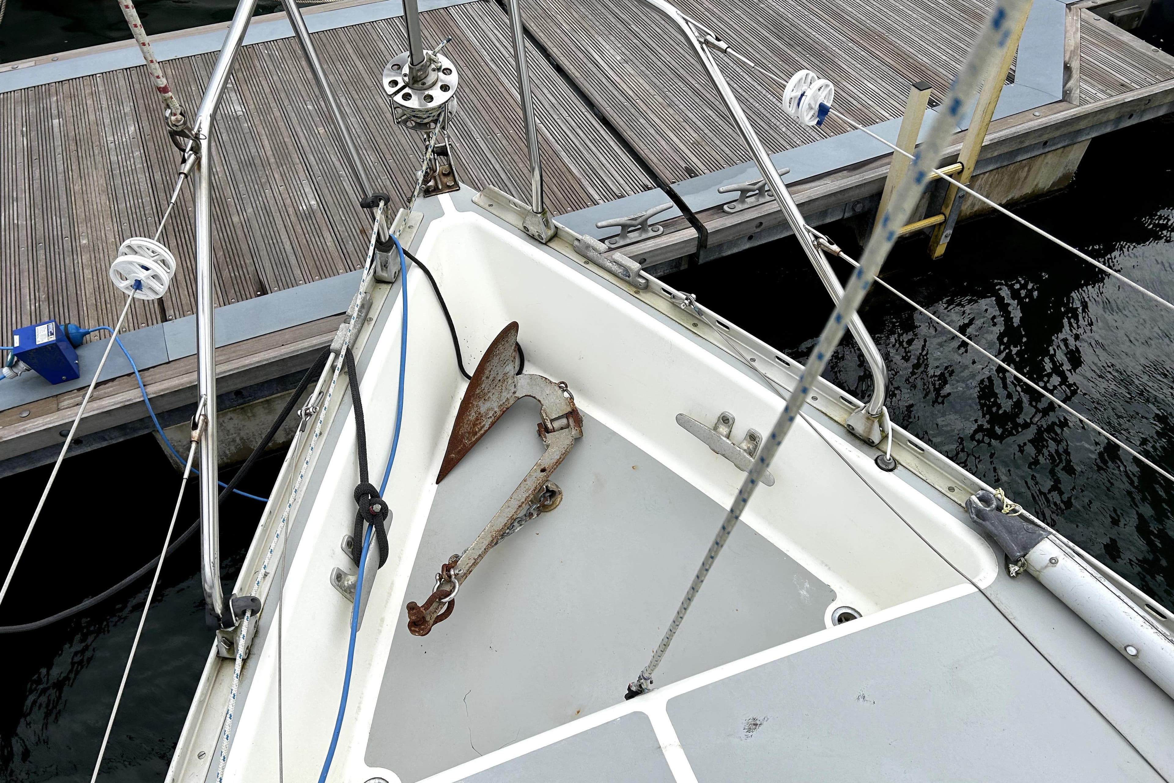 Bow of 1983 Moody 29 sailboat with anchor, docked at marina.