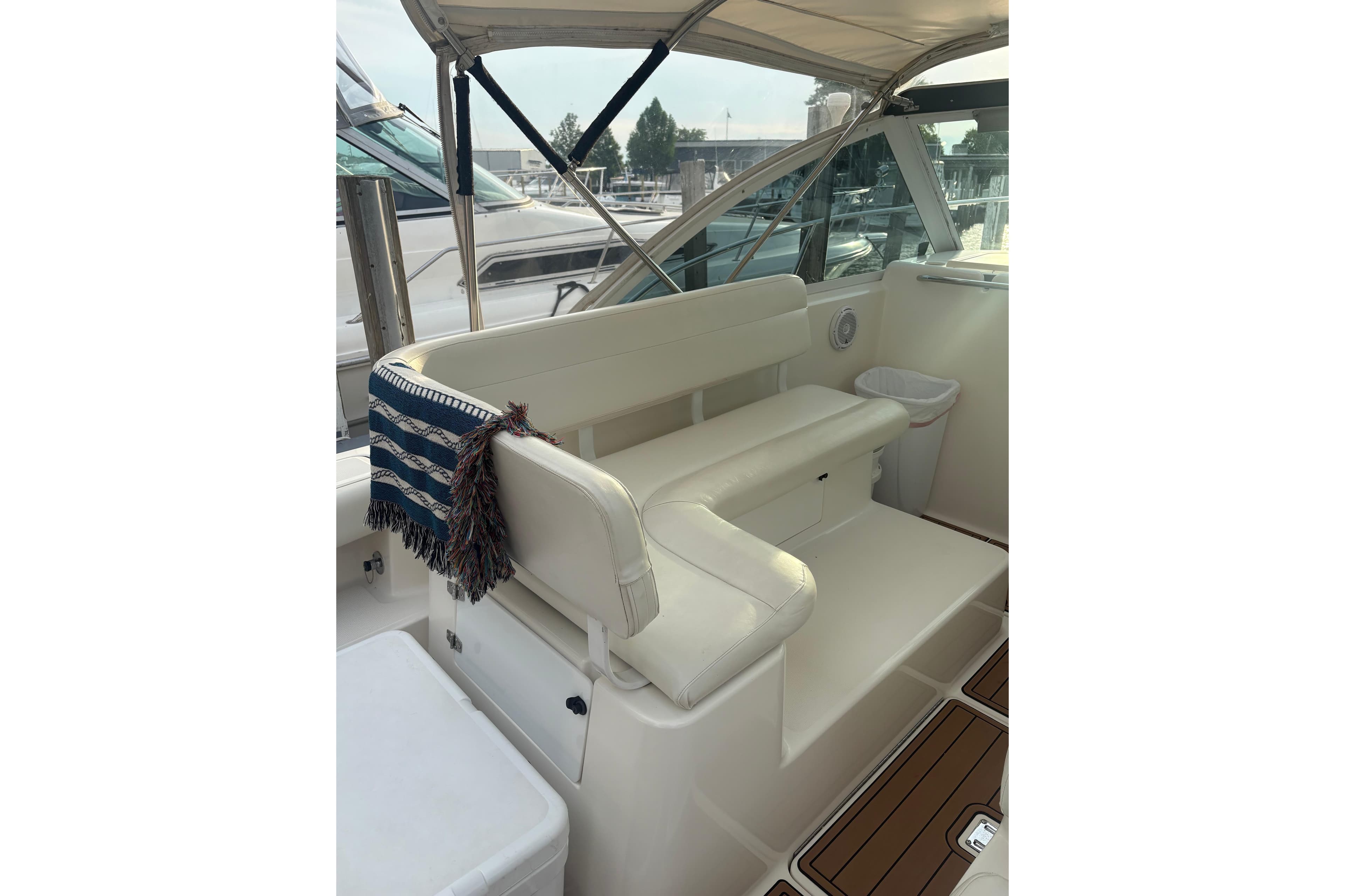 1999 Tiara Yachts 2900 Coronet interior with white seating and striped blanket.