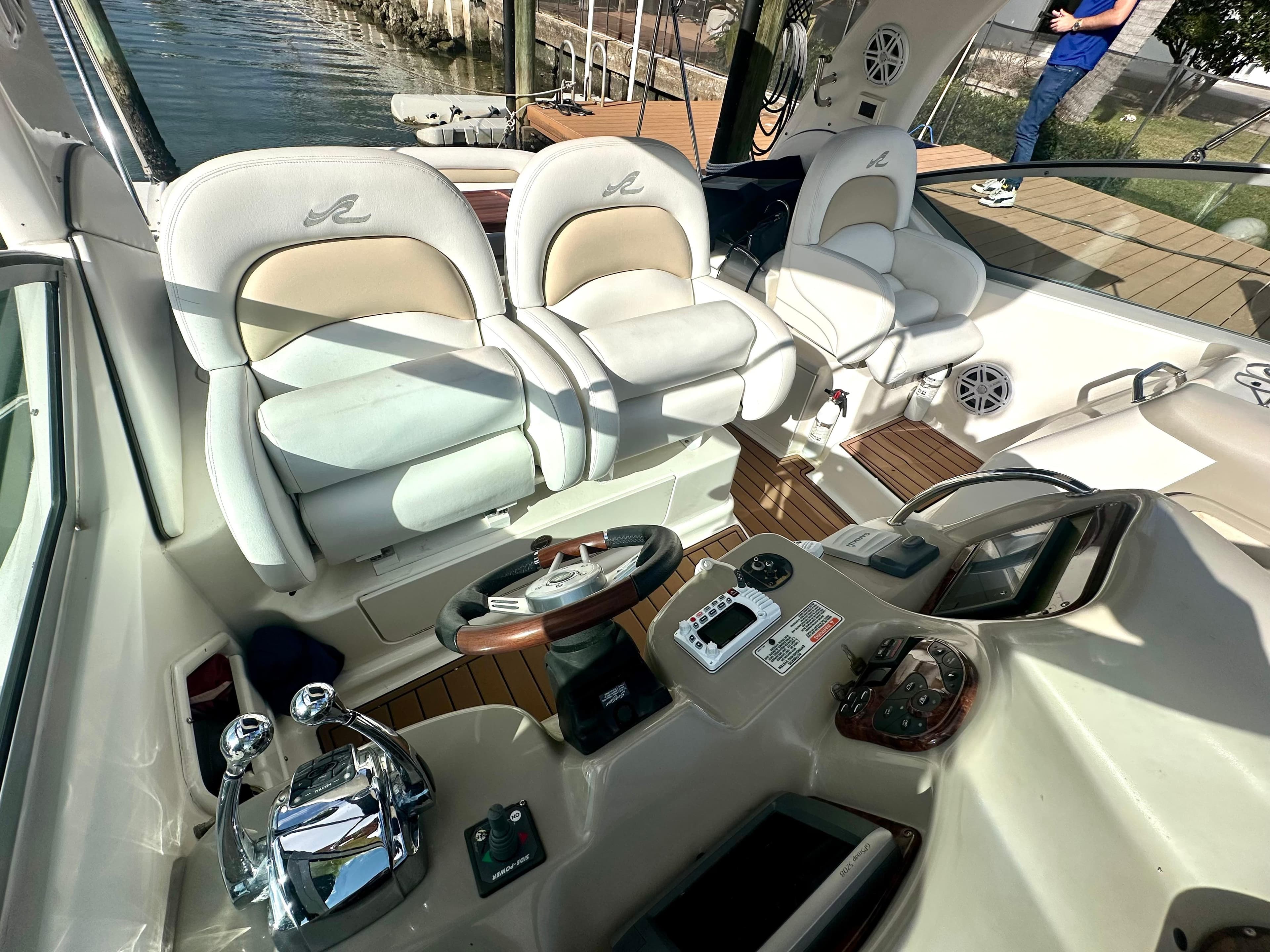 2008 Sea Ray 420 Sundancer cockpit with helm, controls, and seating by the water.