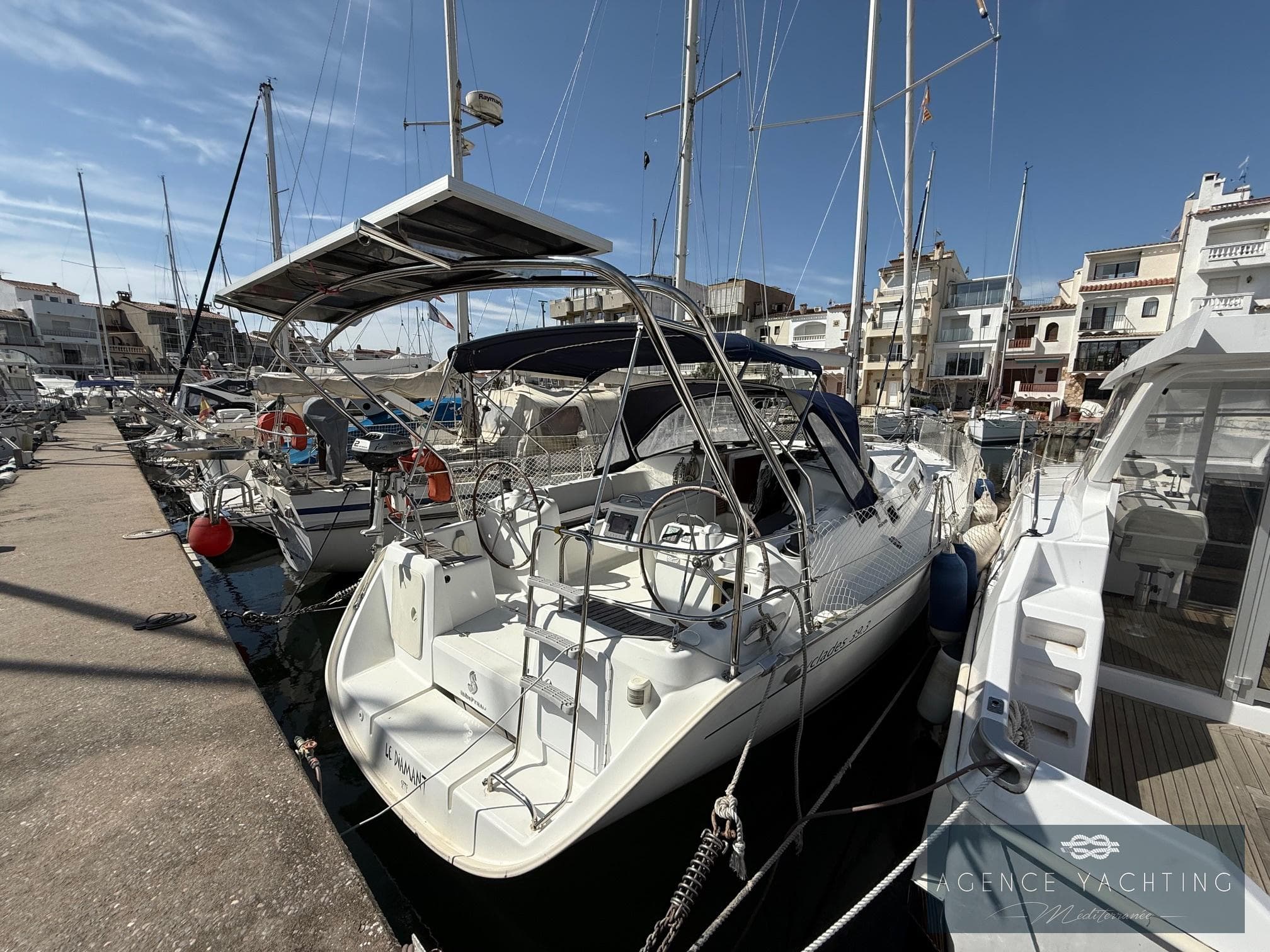 2007 Beneteau Cyclades 39 sailboat docked in a marina under clear blue skies.