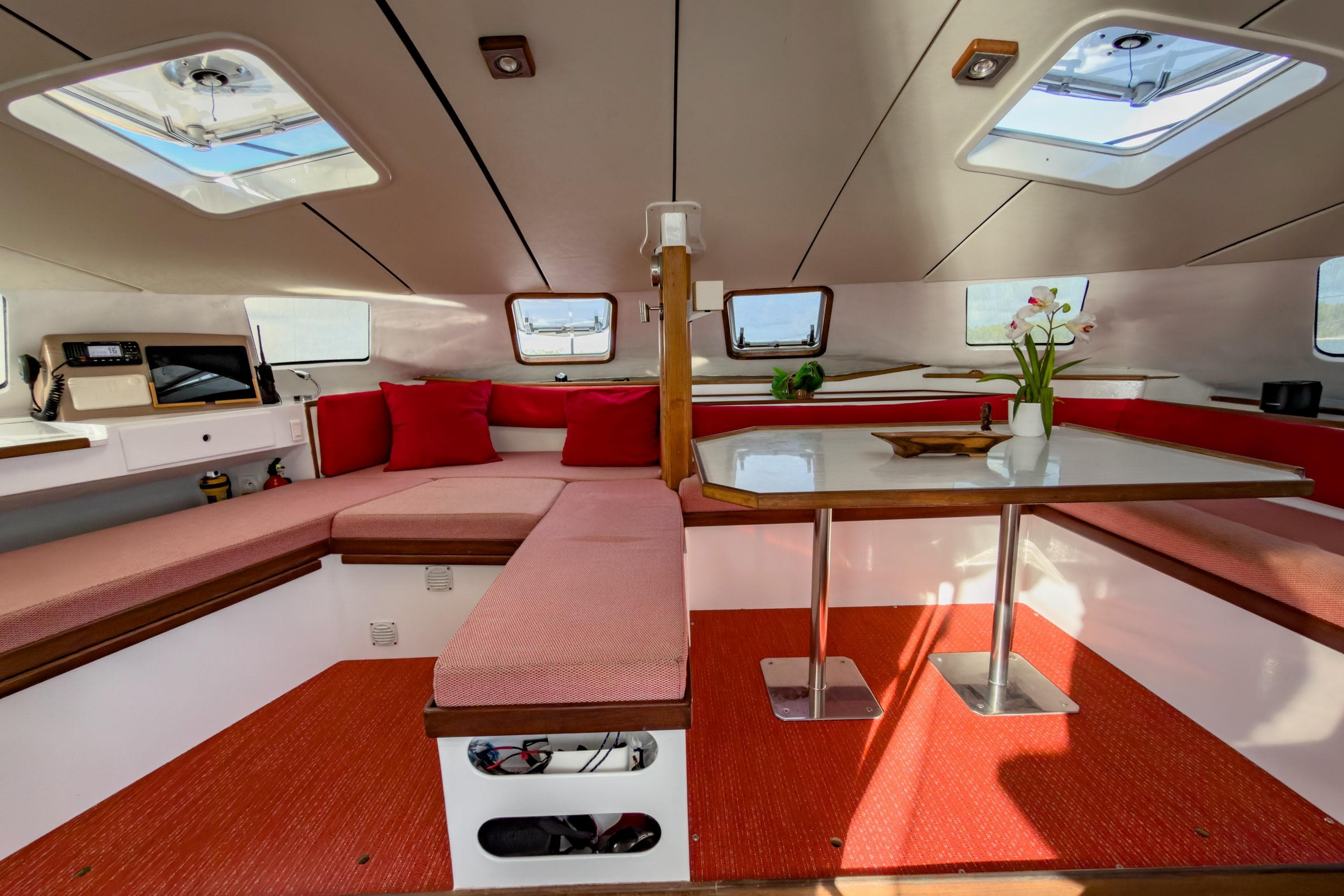 Interior of 2001 Ville Audrain 45 yacht with red seating and white table.