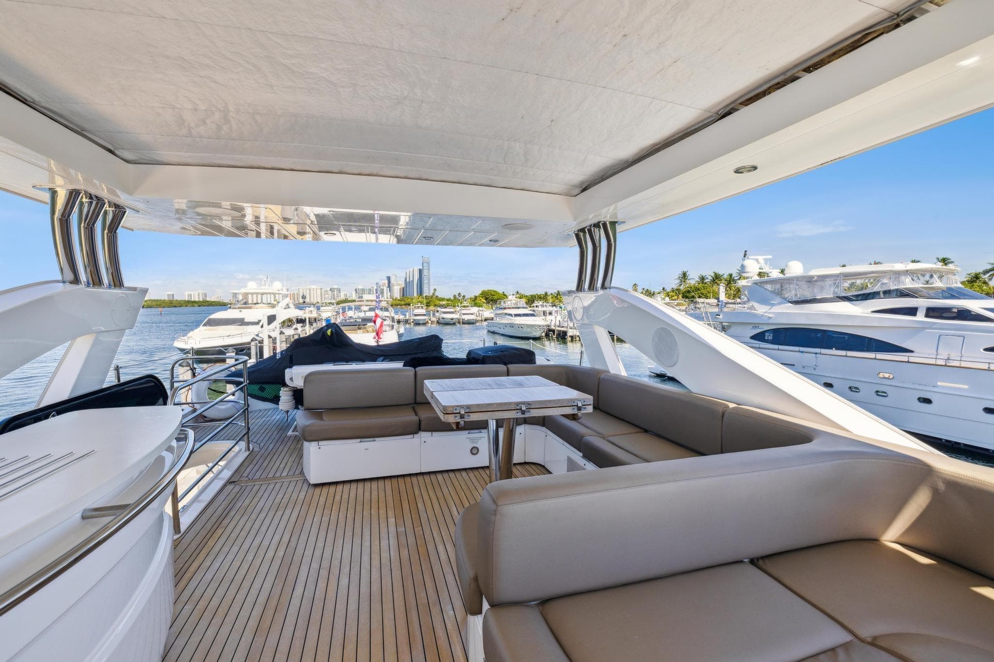 Luxurious 2014 Sunseeker 73 Manhattan yacht interior with spacious seating and scenic marina view.