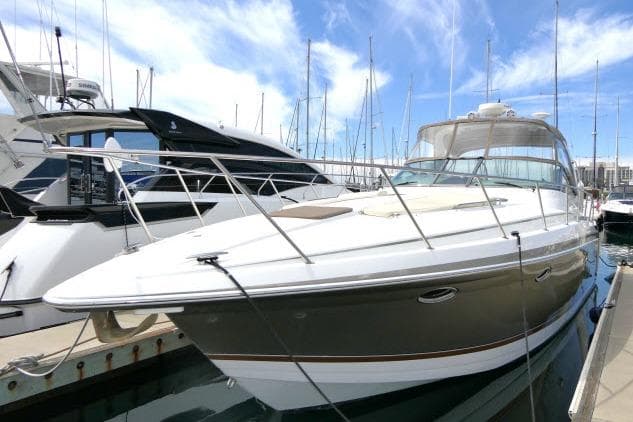 2003 Thunderbird Formula 40PC yacht docked at marina under blue sky.