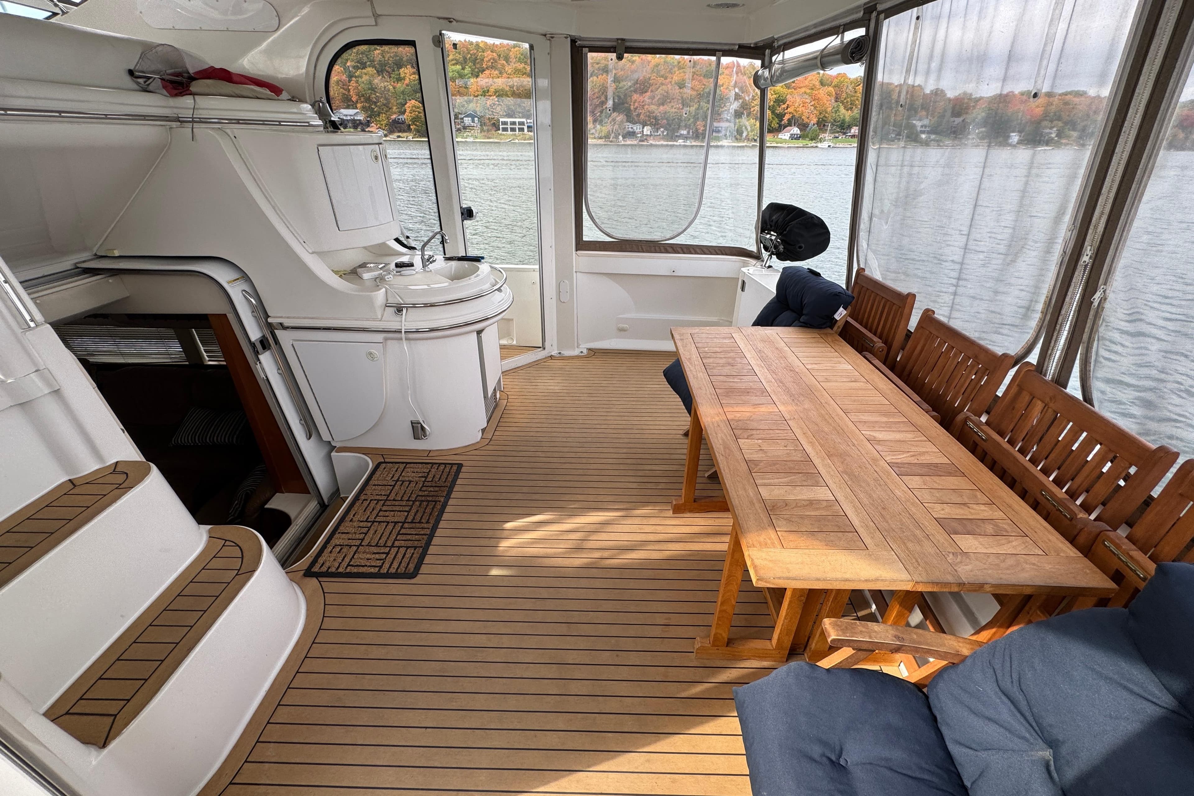 Spacious deck of 2002 Carver 466 Motor Yacht with wooden table and seating.