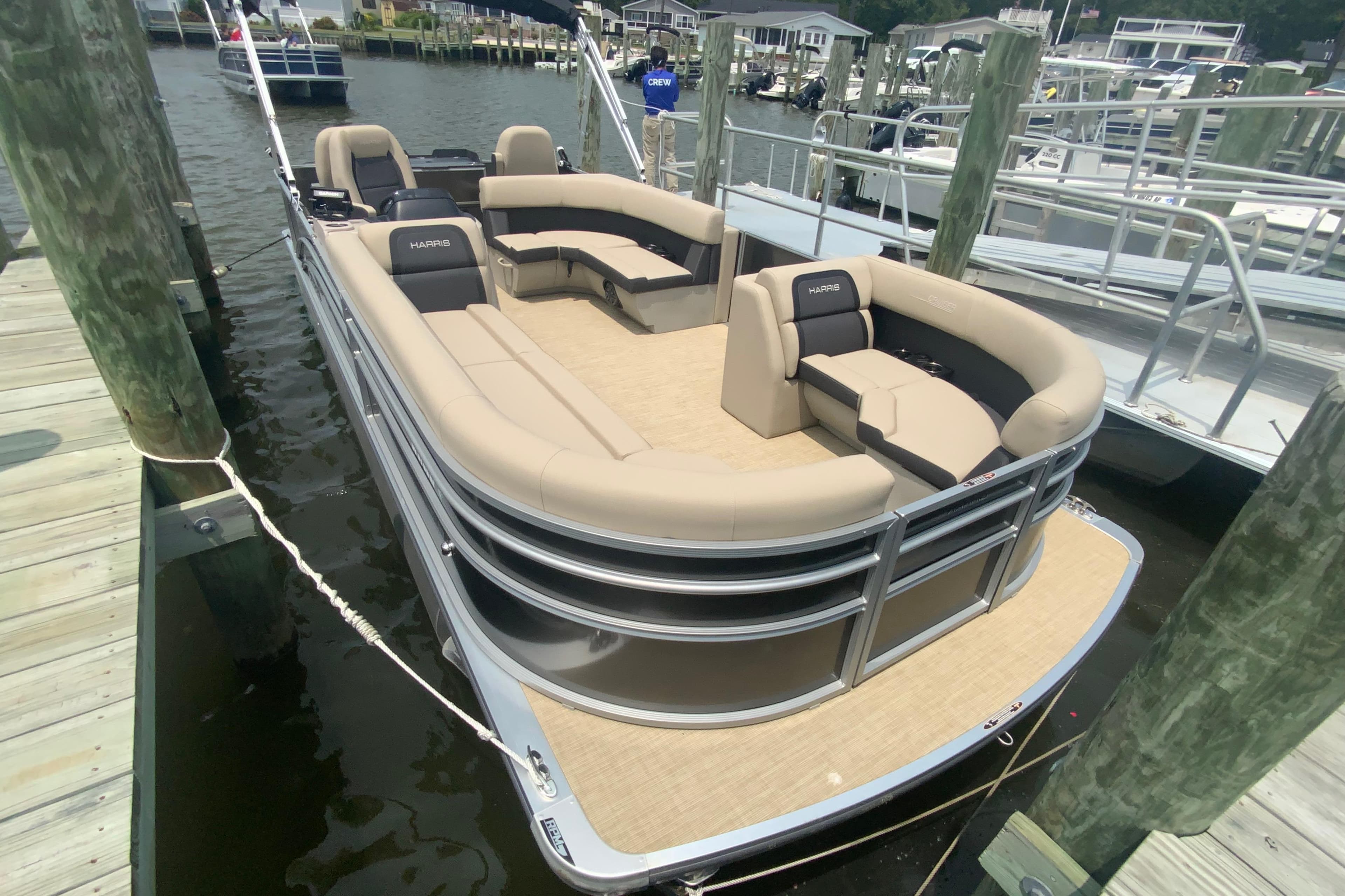2025 Harris Cruiser 230 pontoon boat docked, featuring spacious seating and modern design.