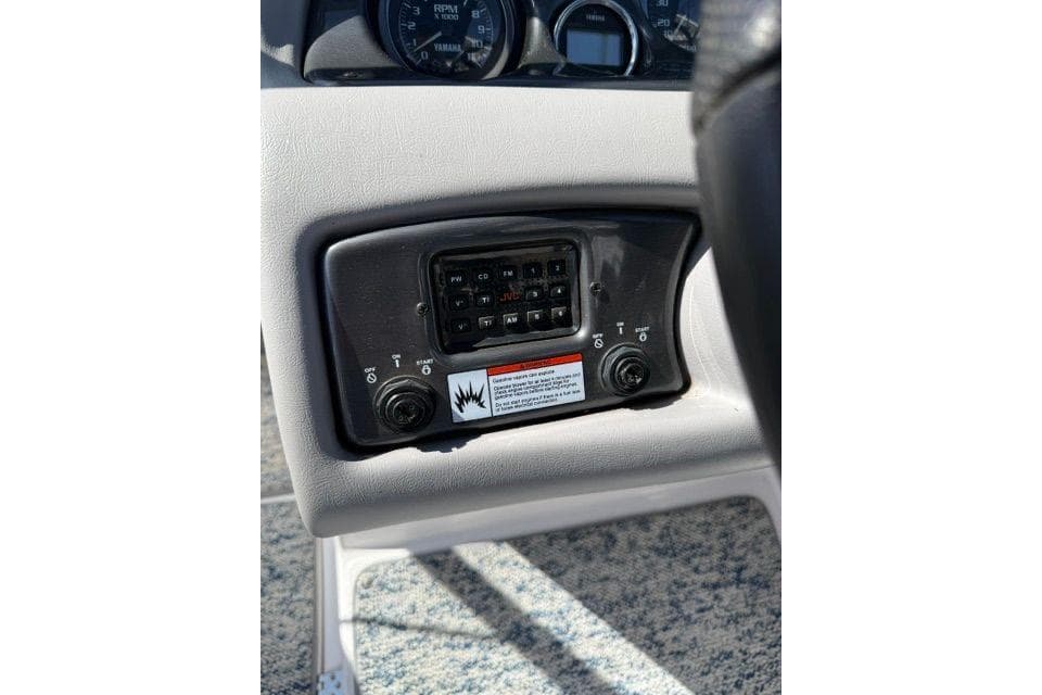 Control panel of a 2004 Yamaha Boats SX230, featuring switches and warning label.