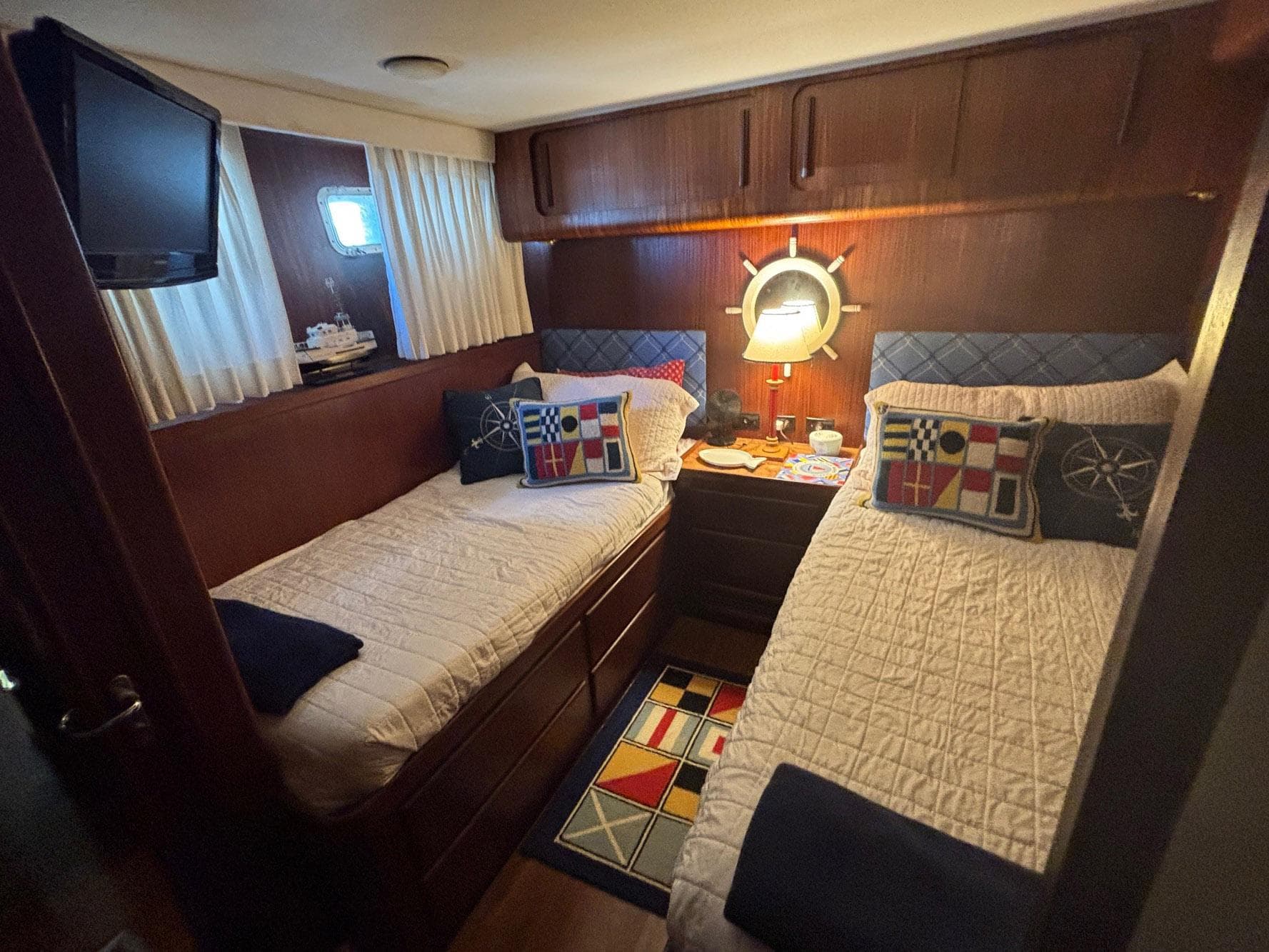 Cozy cabin interior of 1987 Hatteras Flybridge with twin beds and nautical decor.
