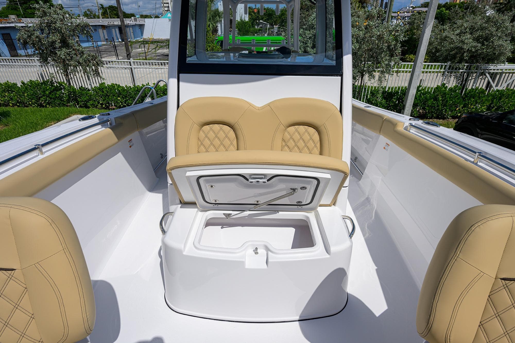 2026 Sportsman Open 302 Center Console boat interior with tan seating and storage compartment.