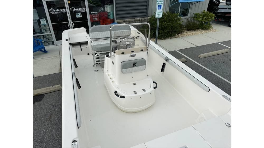 2025 Carolina Skiff 21 LS boat, spacious deck, modern design, parked near a building.