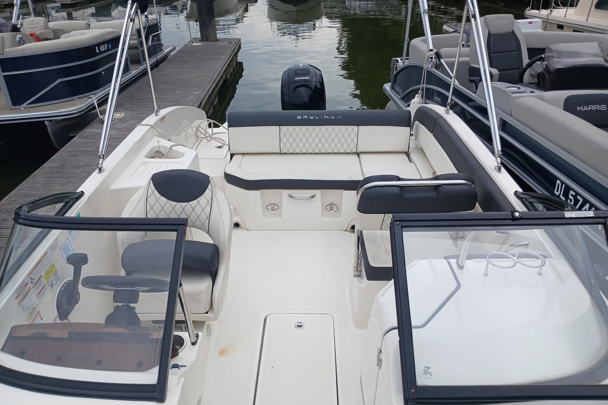 2023 Bayliner DX 2200 boat interior with seating and steering wheel at dock.