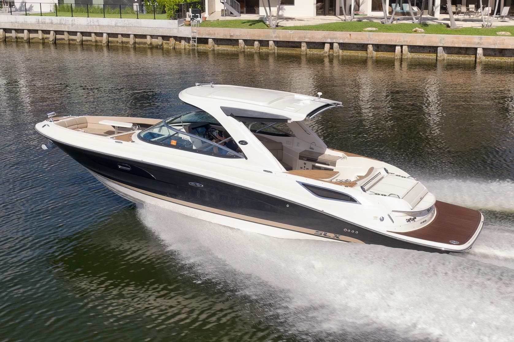 2016 Sea Ray 350 SLX cruising on a calm waterway, showcasing sleek design and luxury features.