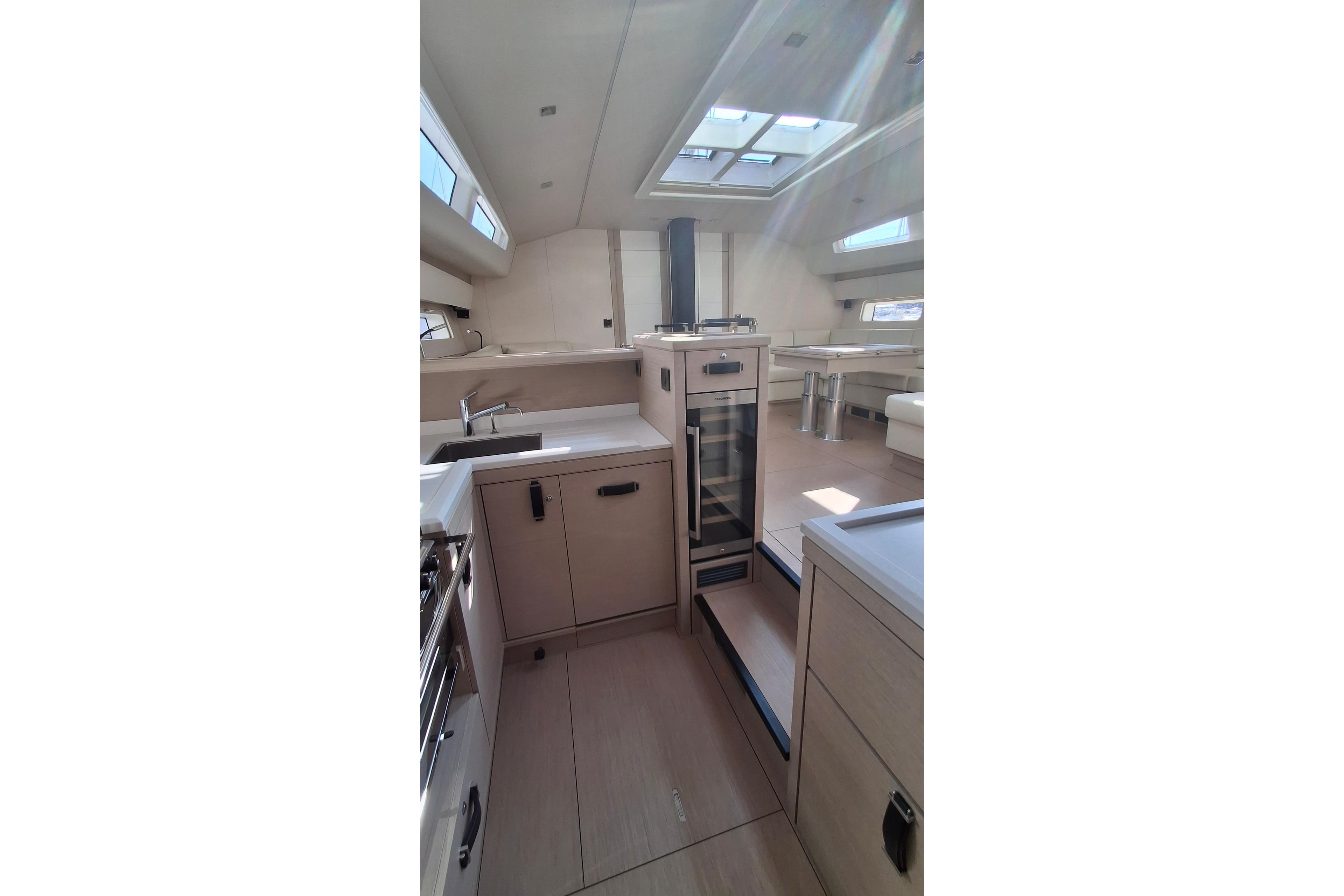 Luxurious interior of 2025 Jeanneau 65 yacht, featuring modern kitchen and dining area.